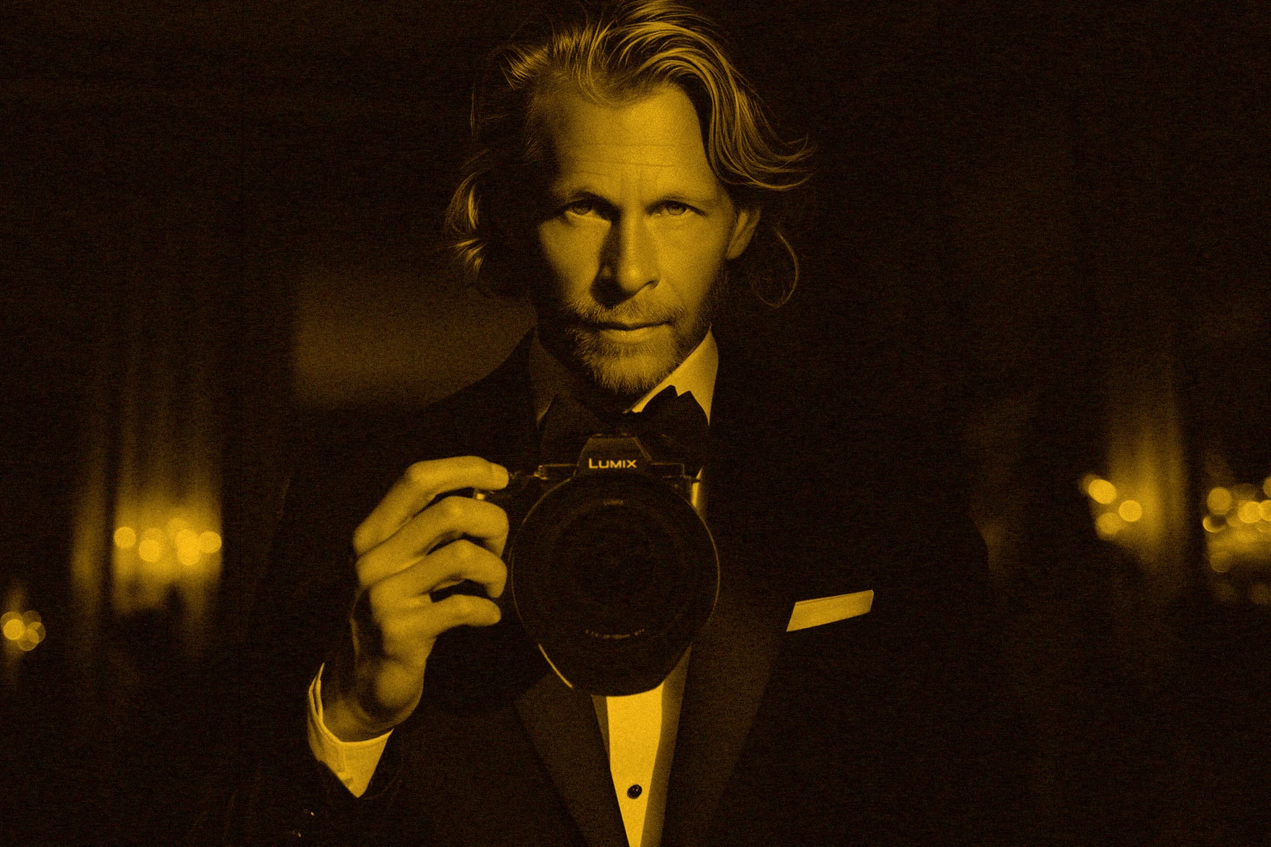Fine art split-toned portrait of photographer and artist Charles Maring wearing a tuxedo and holding his camera.