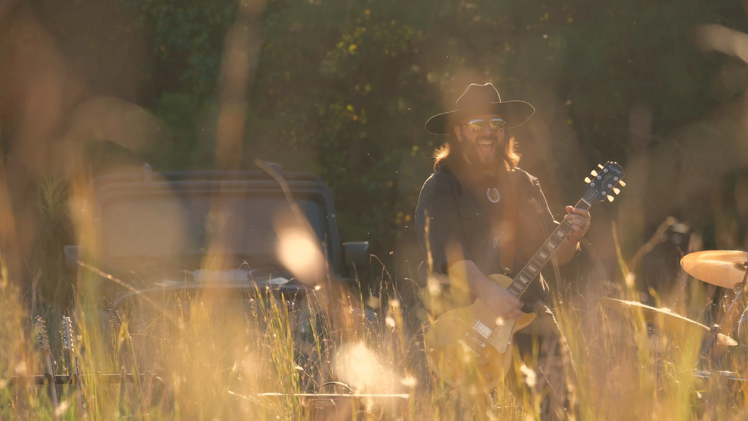 Nic Ziter expressive while performing My Own Doctor with Delta Circle during a golden hour field shoot outside Savannah.