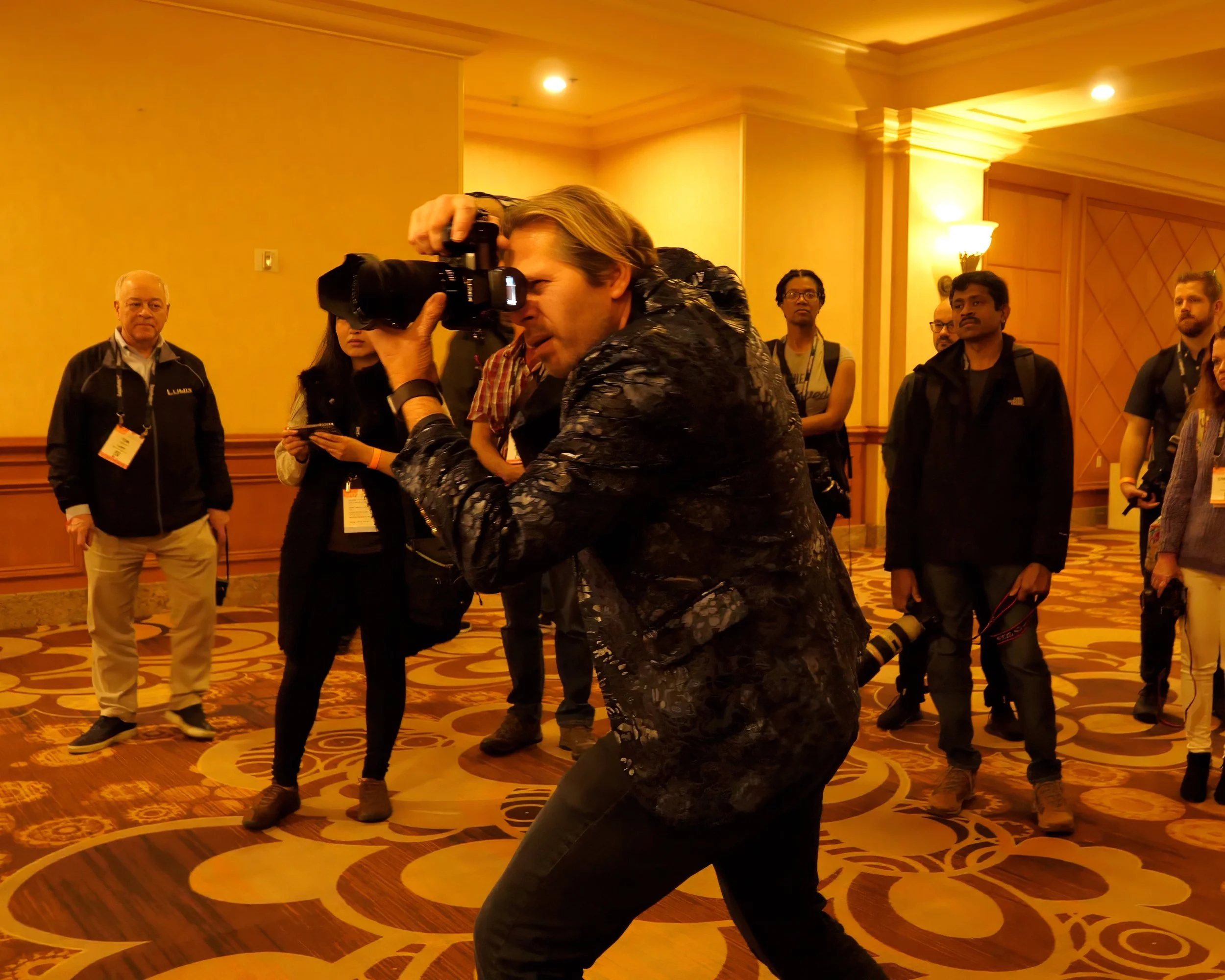 Charles Maring photographs an off-camera subject inside the MGM Grand in Las Vegas as masterclass attendees observe his creative process.