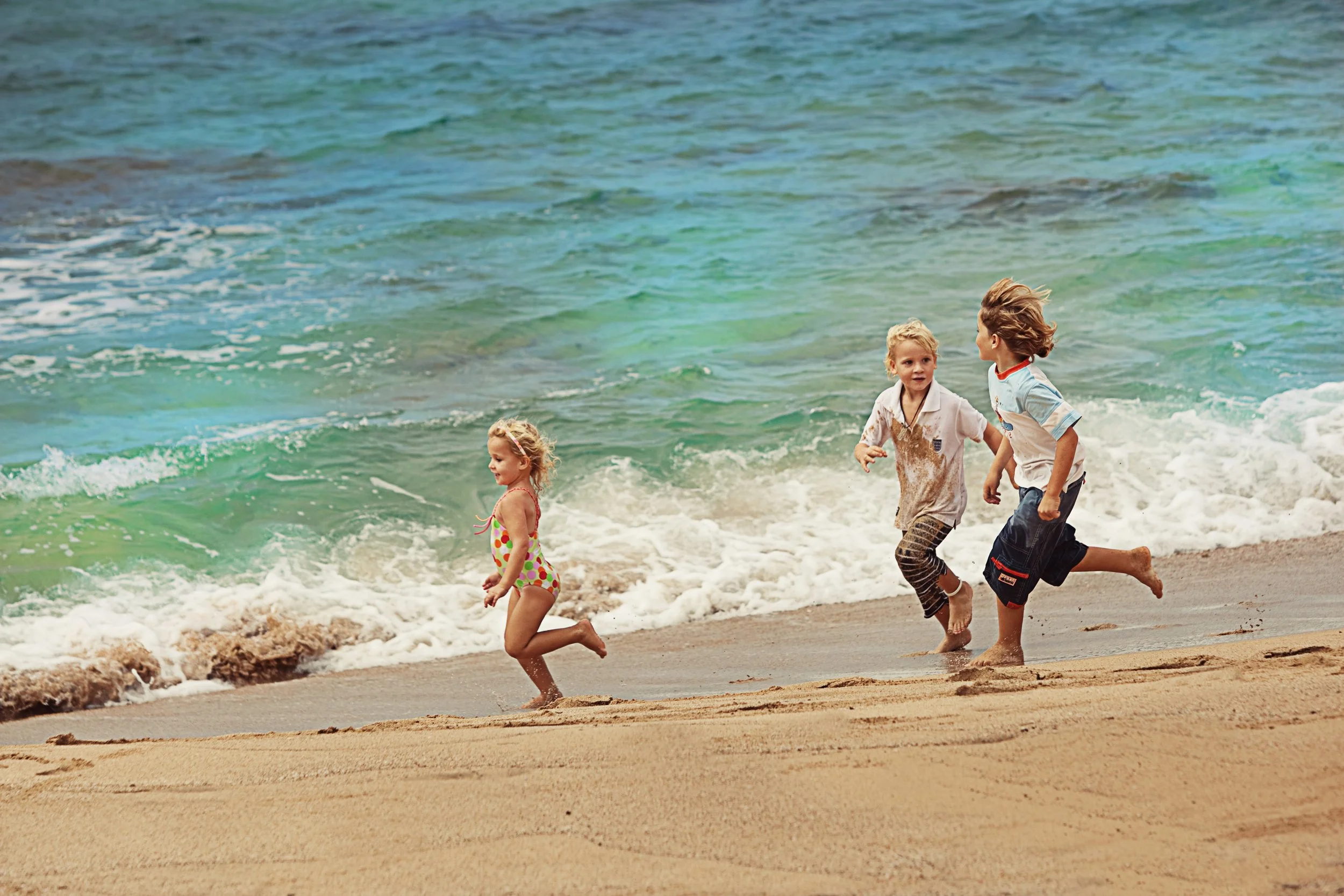 A spontaneous childhood moment at the edge of the ocean, photographed through movement, expression and natural light.