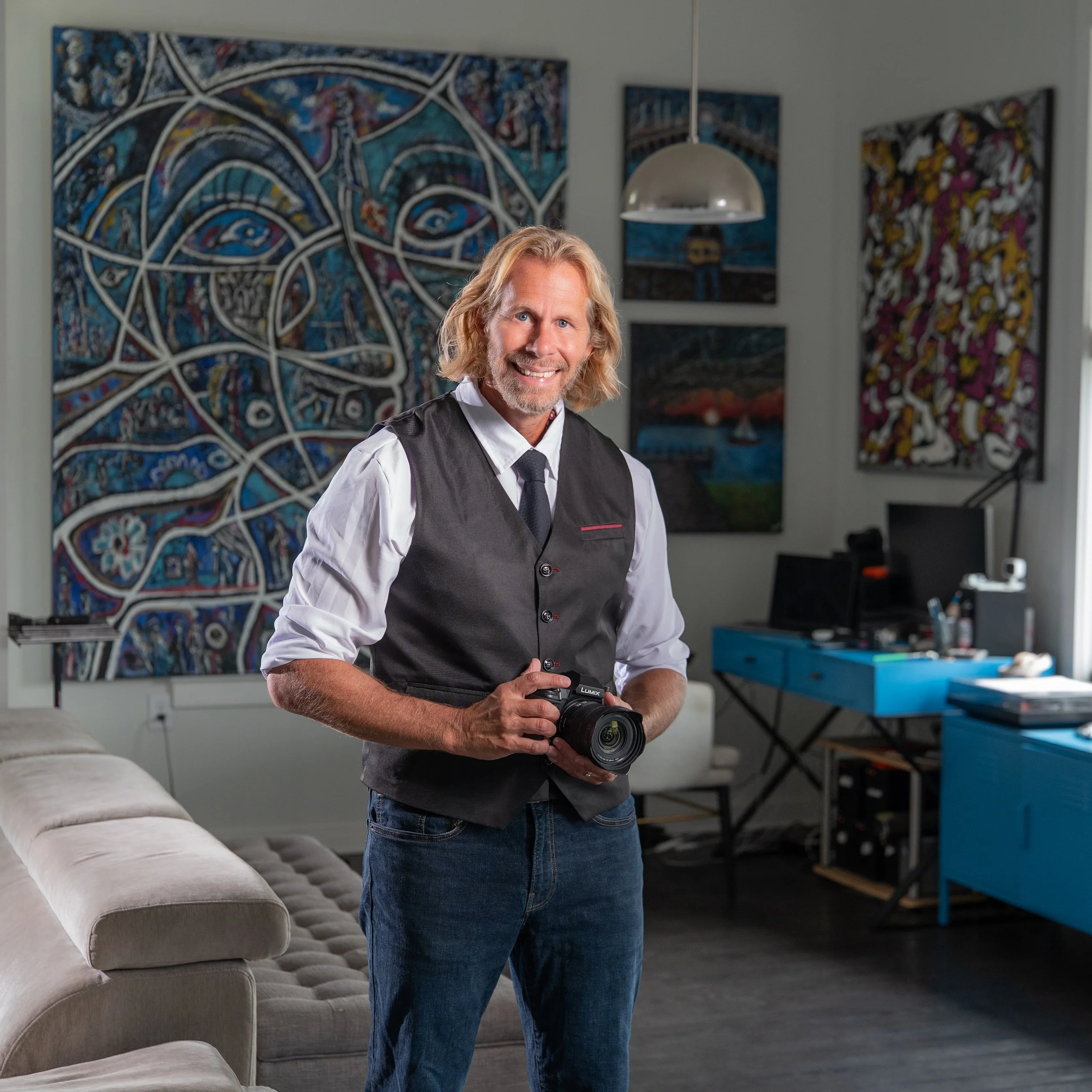 Portrait of Charles Maring holding a camera inside his downtown Savannah art loft.