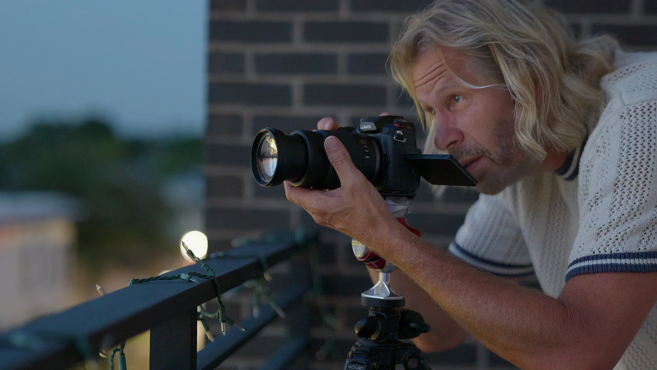Photographer Charles Maring prepares a camera on the terrace of his Savannah loft as morning light reaches the city.
