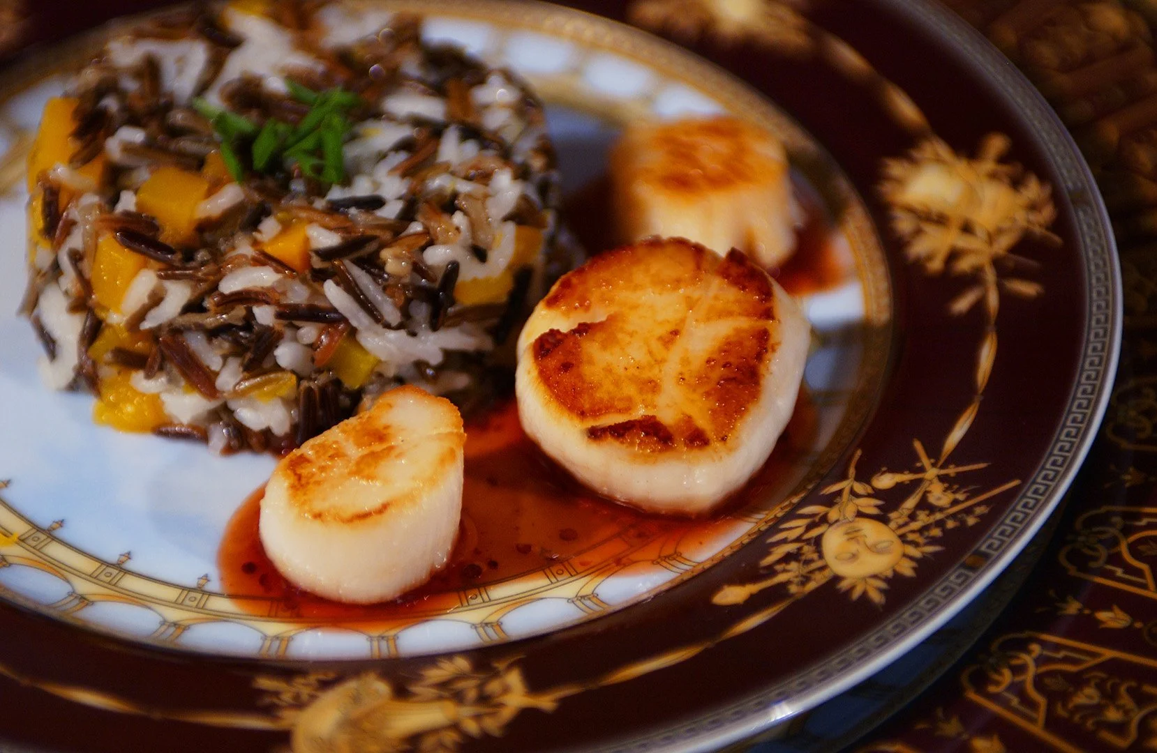 Seared scallops and wild rice photographed as a study of cuisine, presentation, color and detail.