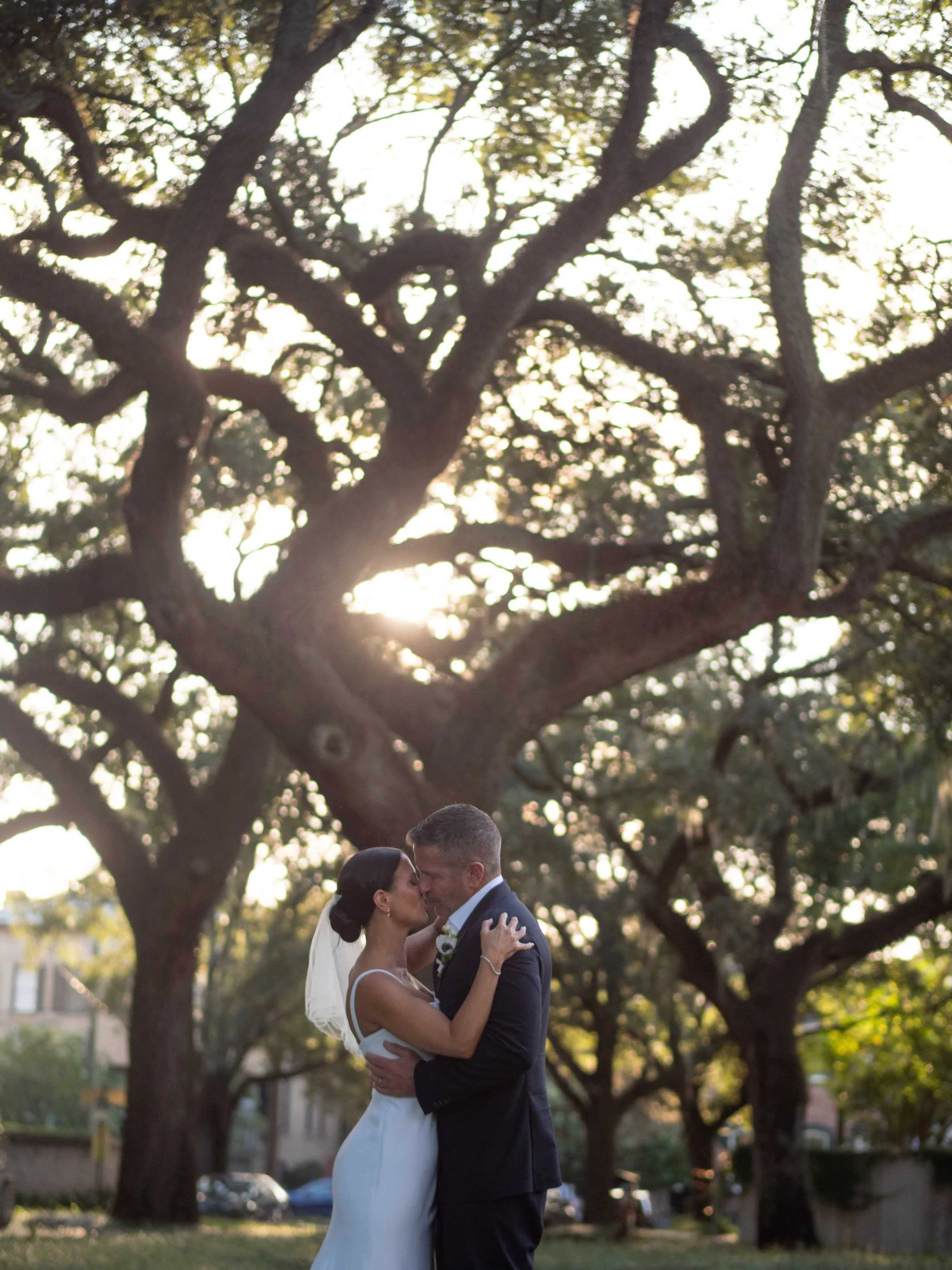 Kate and Ryan kissing beneath a sprawling live oak after their Pulaski Square ceremony