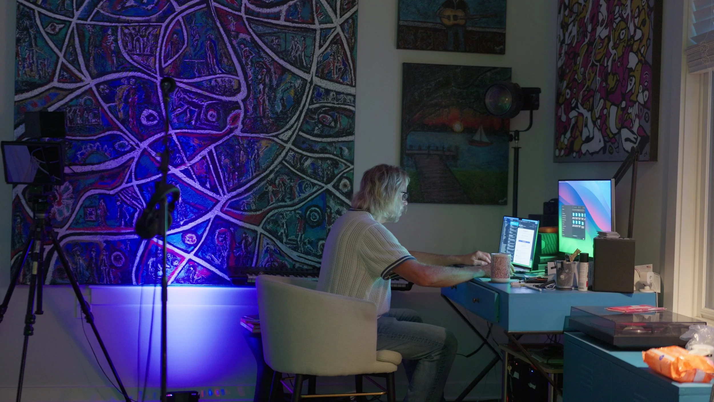 Charles Maring works at a computer surrounded by original paintings and filmmaking equipment in his Savannah studio.