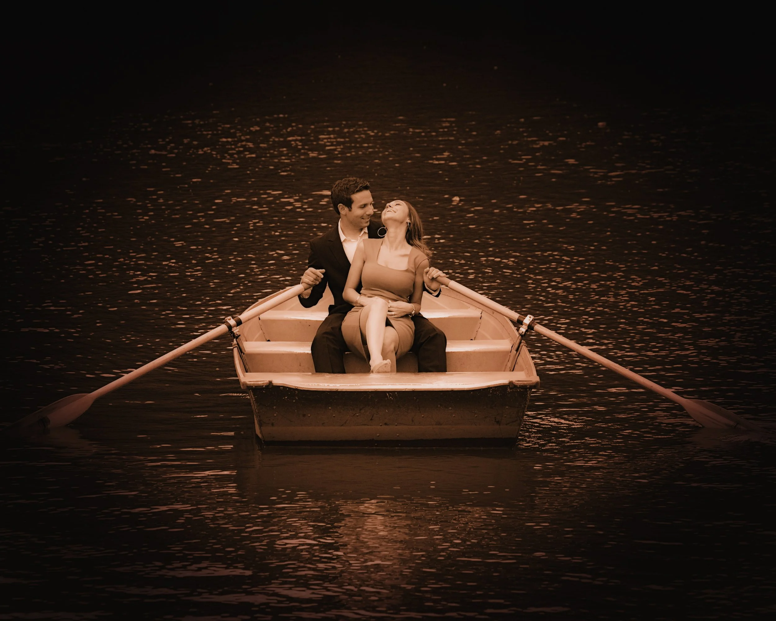 A quiet portrait of a couple on the lake in Central Park, photographed from a distance as an intimate moment within the landscape.