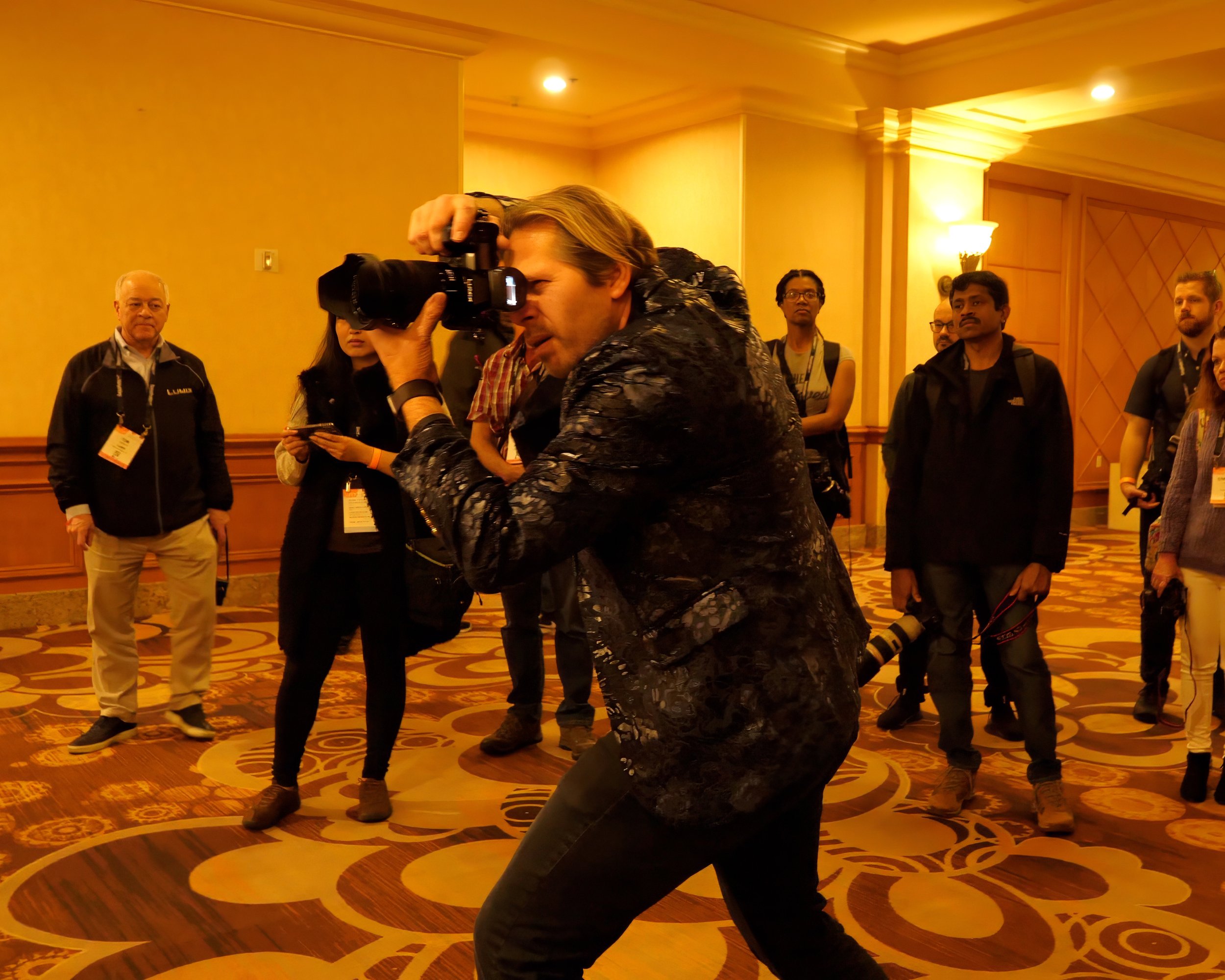 Charles Maring demonstrating professional photography techniques to an audience during an educational conference session.