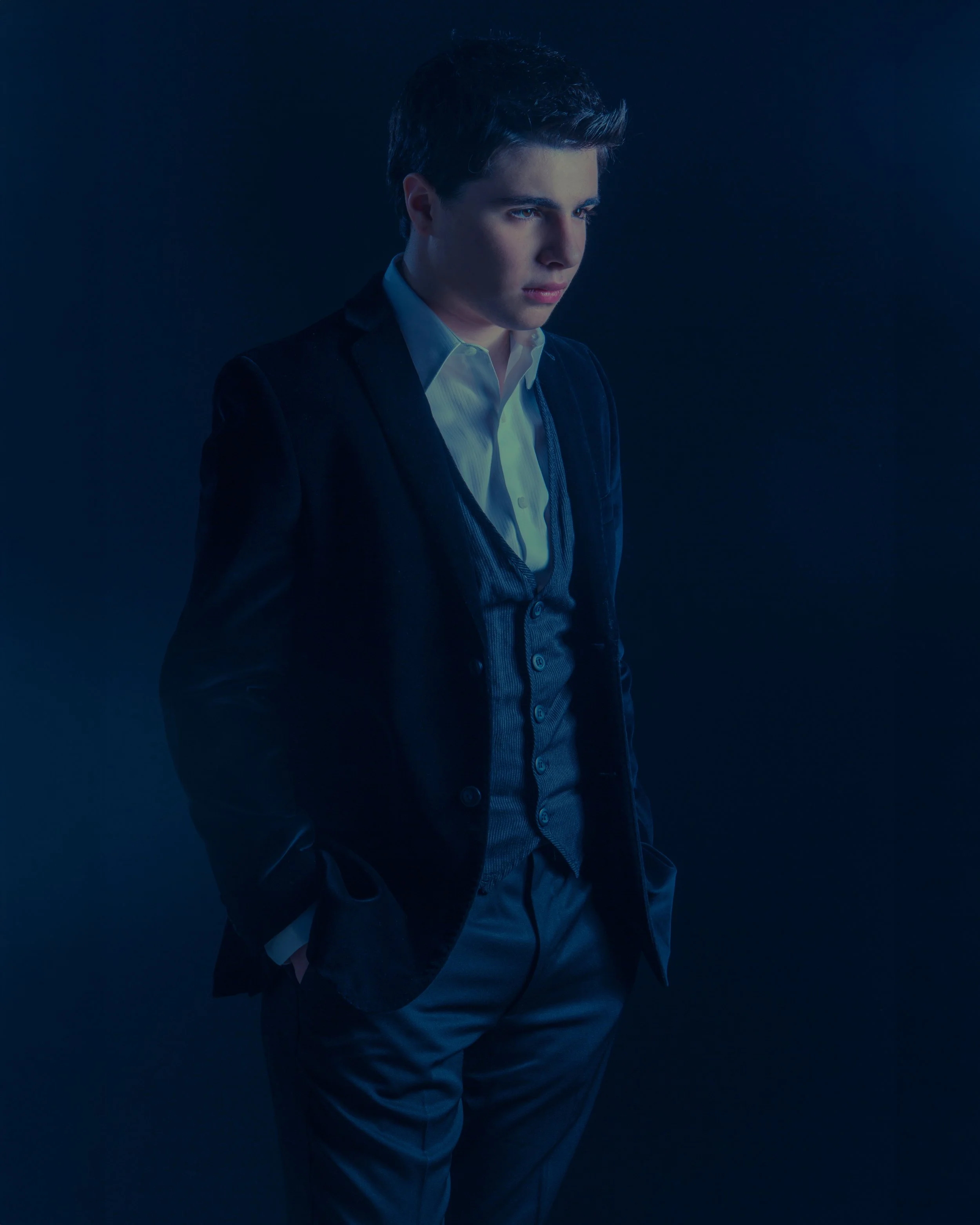 A men’s fashion portrait created through dramatic blue light, styling and intention, showing how some photographs are discovered while others are carefully constructed.