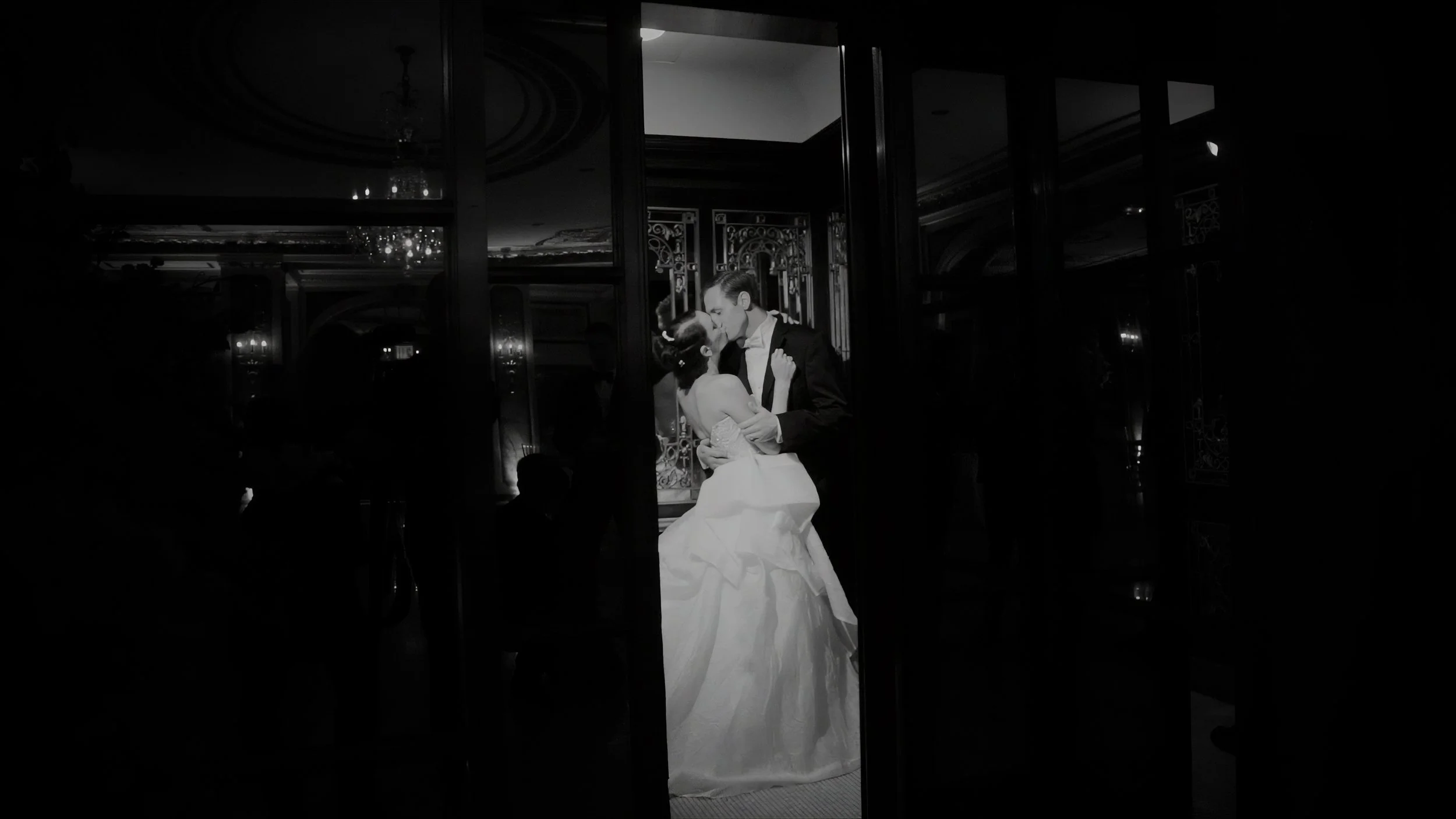Bride and groom kiss in a doorway inside The Plaza Hotel during their New York wedding.