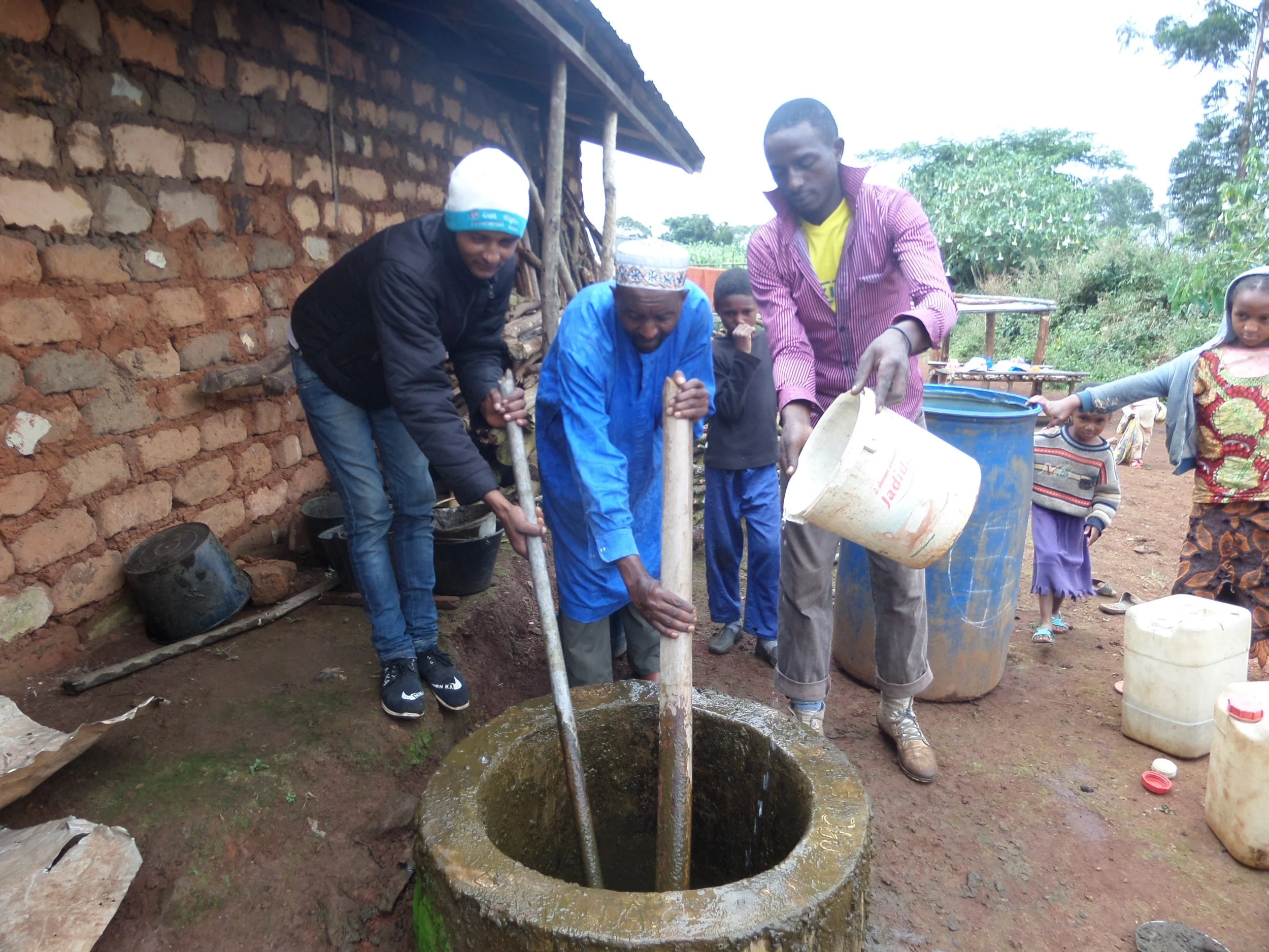 Alhadji (centre) tending to his biogas system. As president of his local Dialogue Platform, he also takes a central position in mediating disputes in his community.
