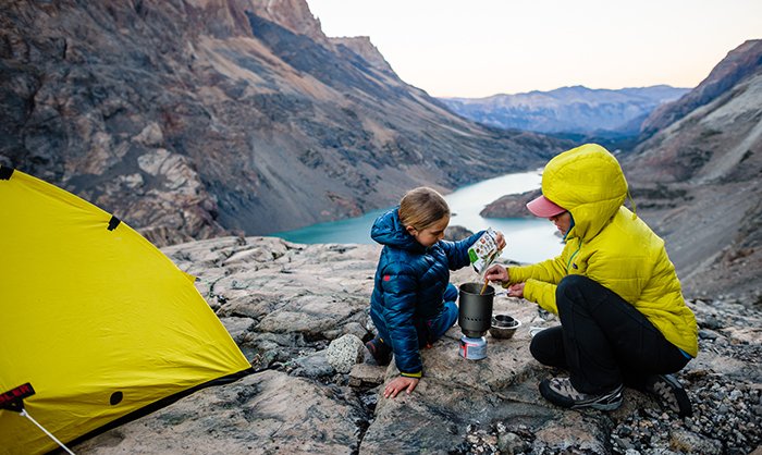 Yellow tent in the mountains with a mother &amp; daughter