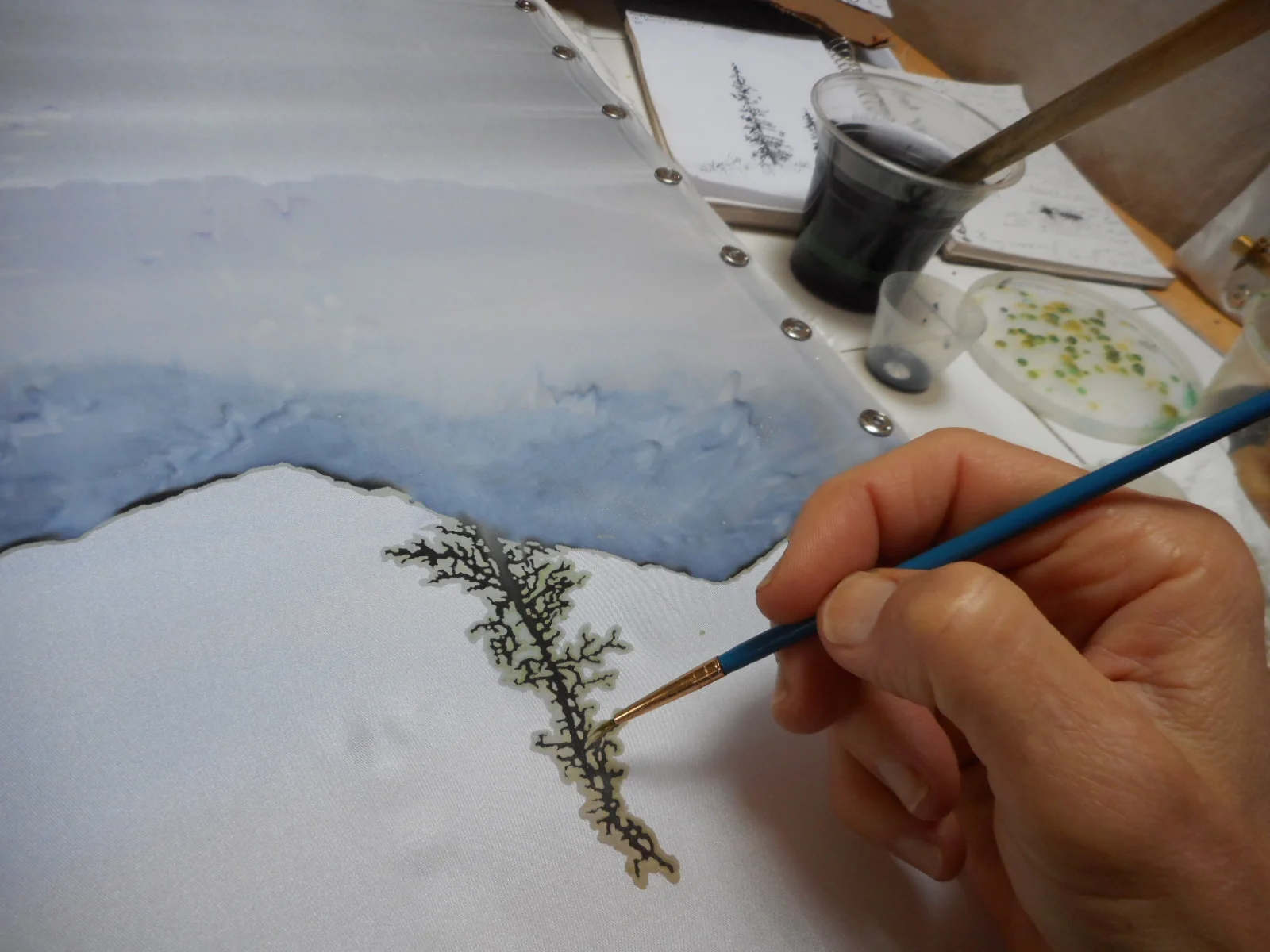 After wax has been applied around the image, silk dyes are then used.