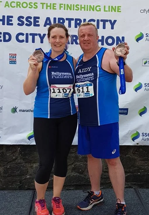 Lynsey McKeown and Adrian Dodds proudly display their Walled City Marathon medals