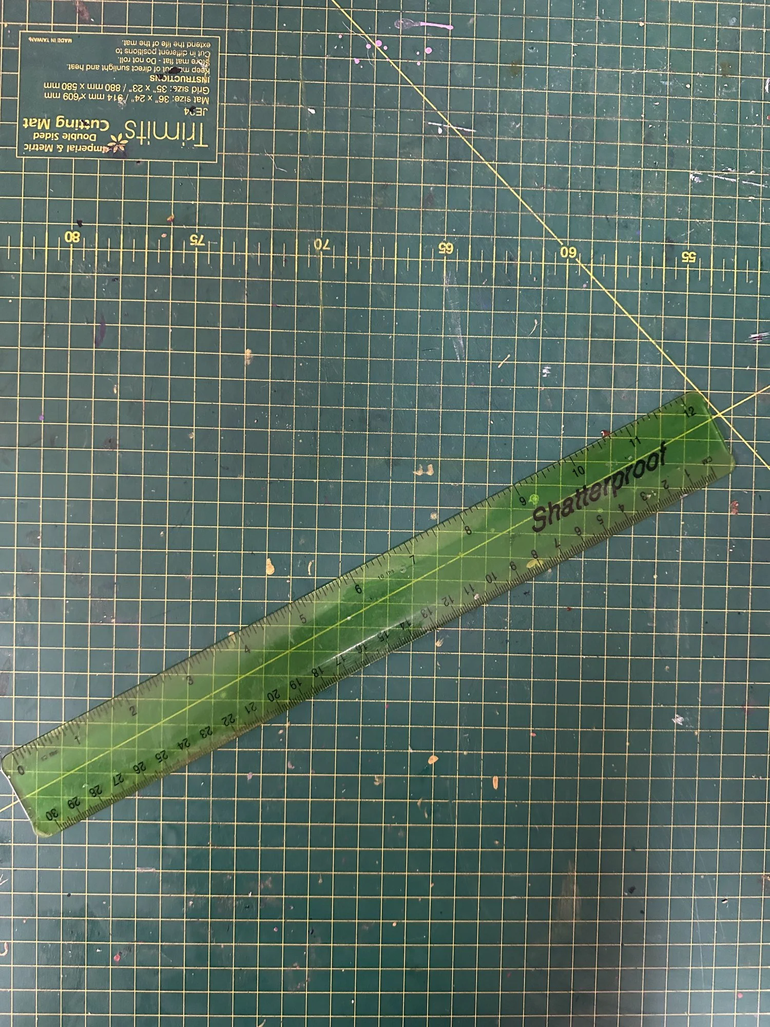 A green shatterproof school ruler, too big to fit in your pencil case