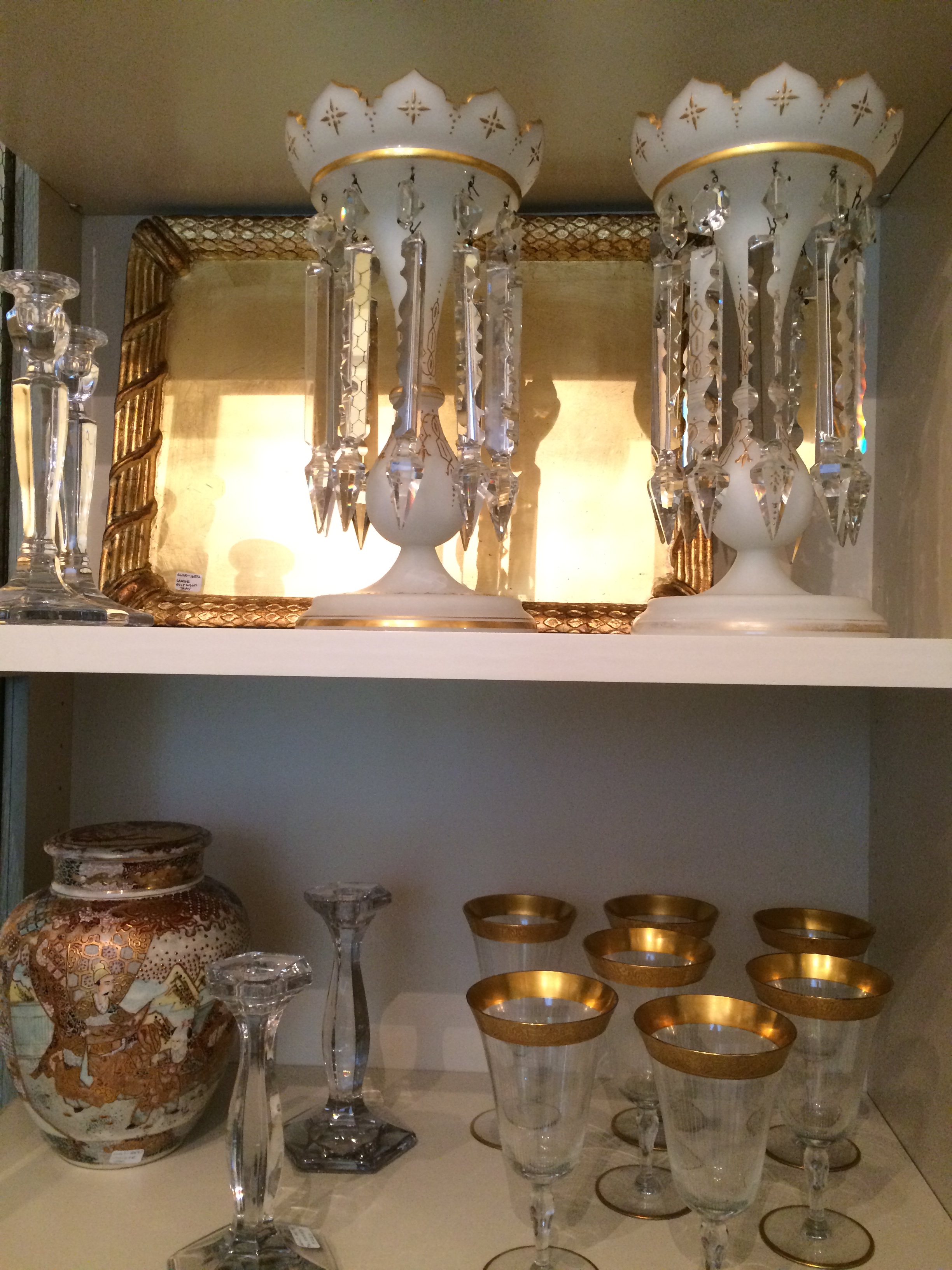 A close up of a cabinet full of lusters and stem ware.