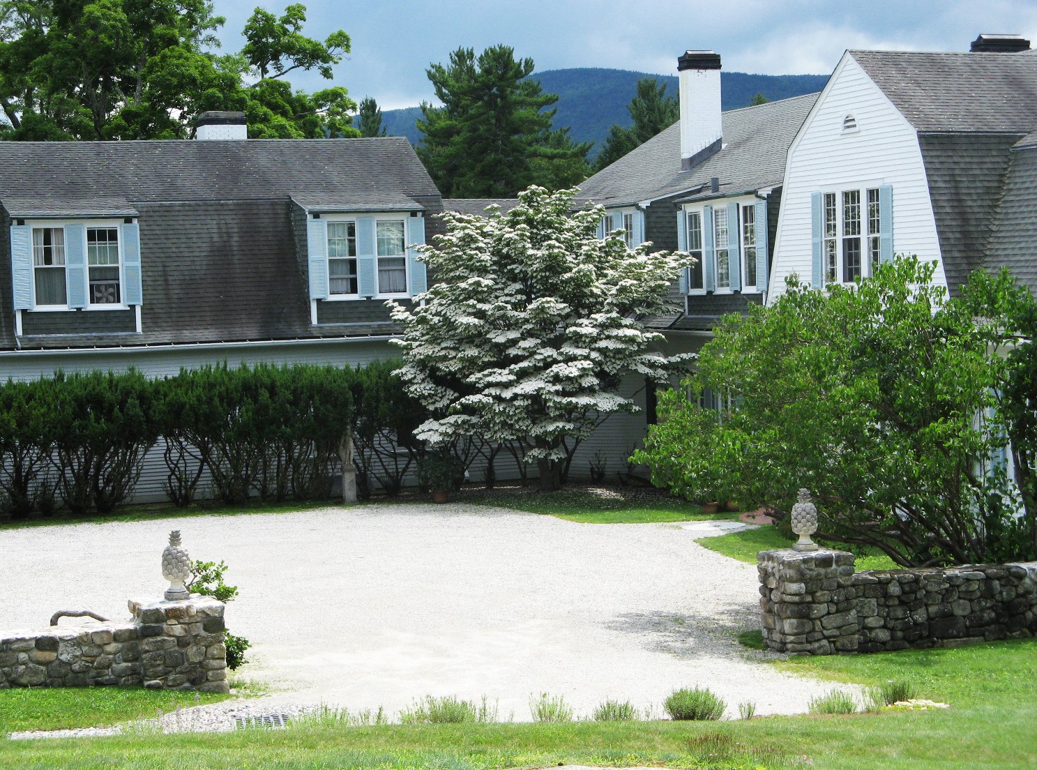 The Pebble Court is graced by a Kousa dogwood, yew hedge, trumpet vine and historic Hay statuary.