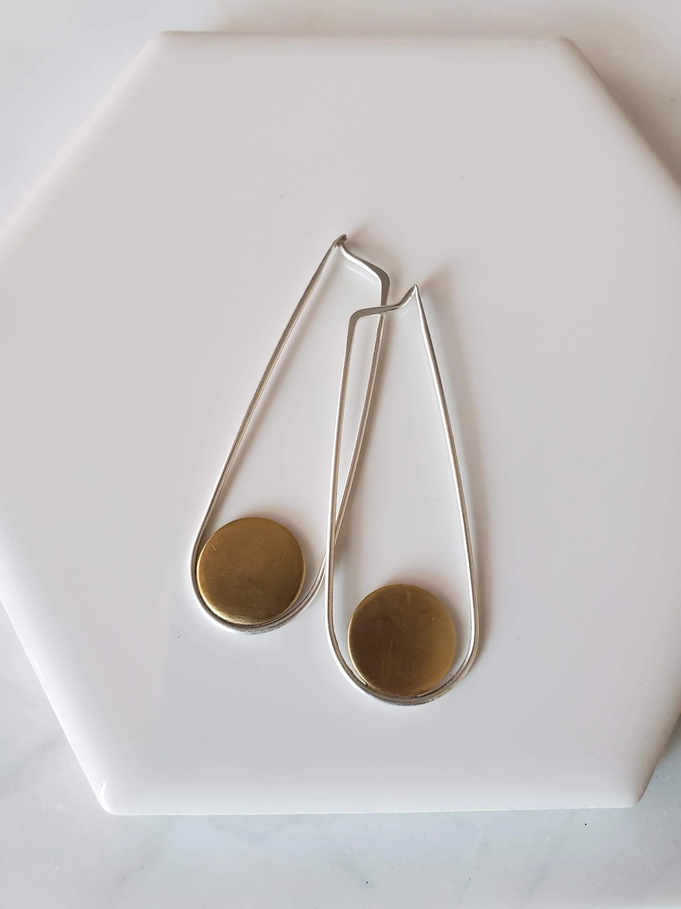 Long shiny silver and brass hoop earring with circle detail