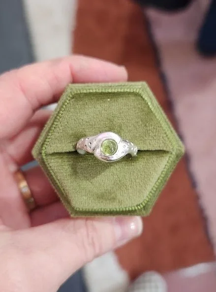 Erik made this beautiful sterling silver ring with a peridot gemstone in my custom wedding ring class a couple weeks ago. While this isn't a wedding ring, it is just as special. A ten year anniversary gift for his wife, Erik carved the shape and text
