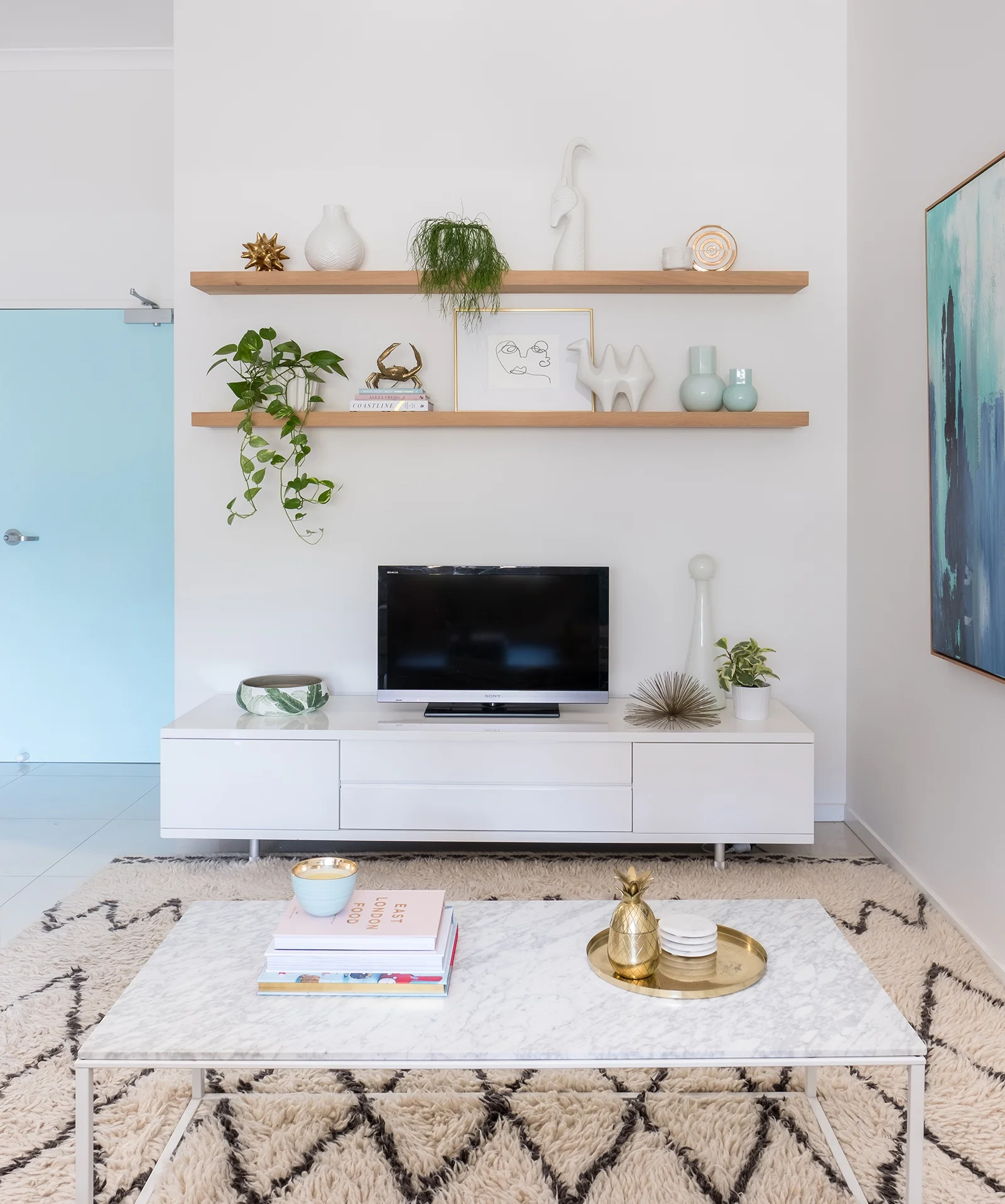 loni_parker_living_room_blue_floating_shelves_clickon_west_elm_rug.jpg