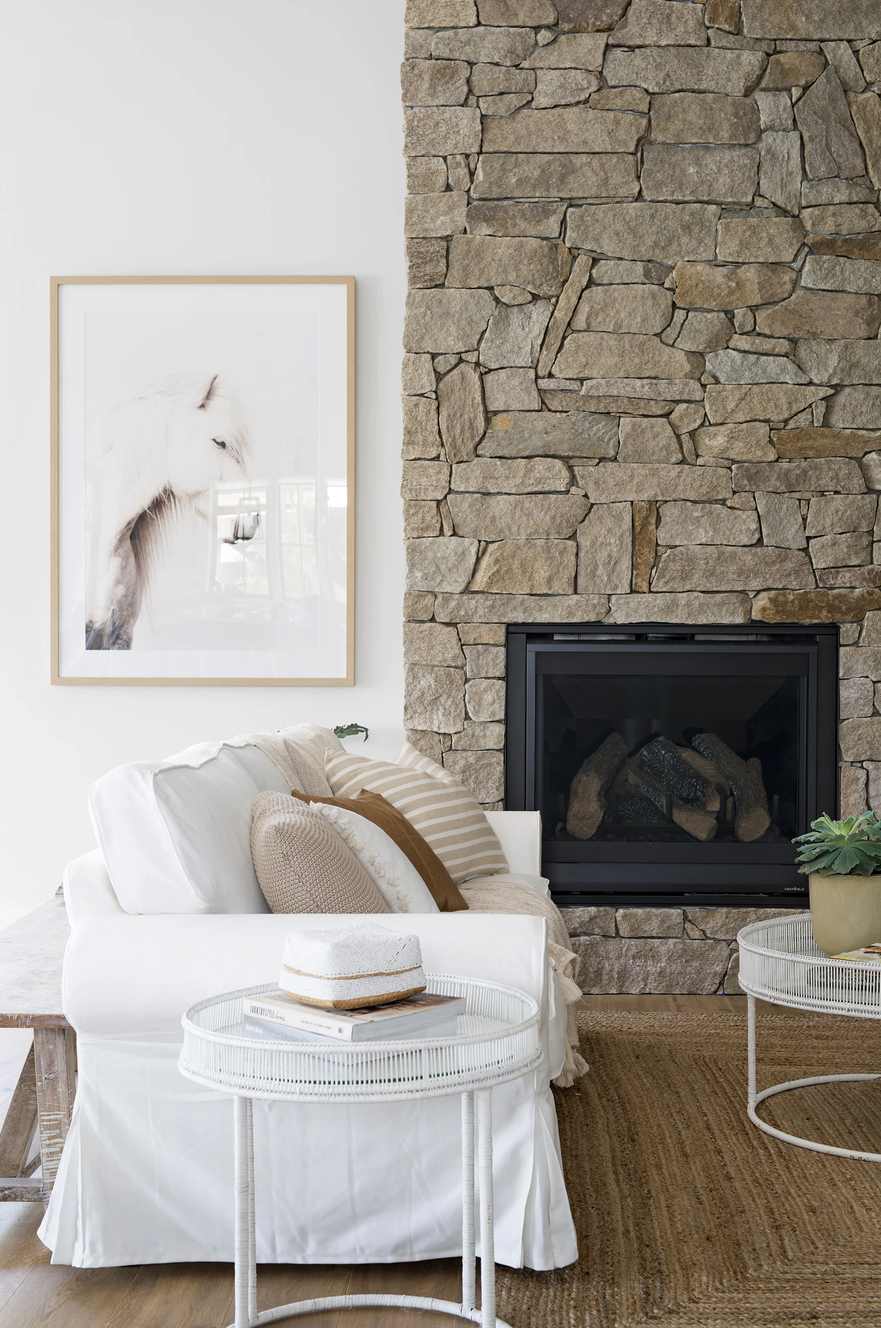 The stone veneer from Infiniti Stone (on the fireplace) creates an authentic farmhouse-style space. Horse print from Urban Road.