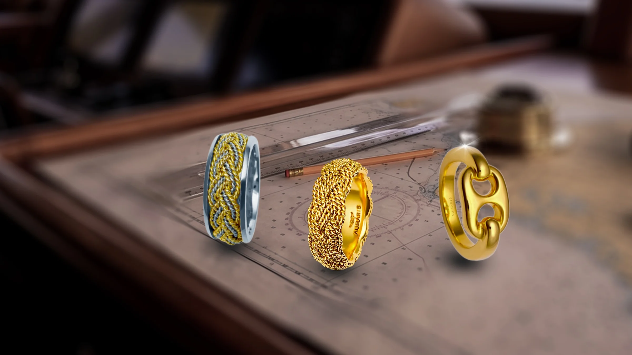 Three nautical gold and platinum rings with handwoven designs are placed on a nautical chart with a ruler and pencil nearby.
