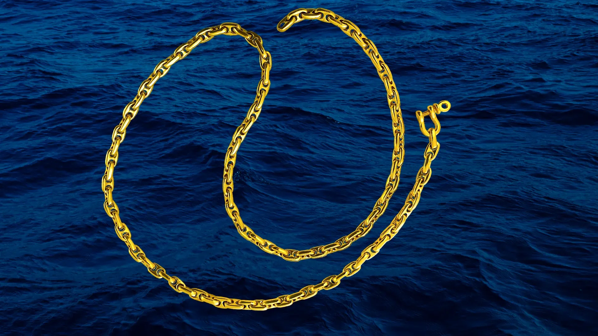 Gold anchor chain necklace and bracelet floating on the ocean.