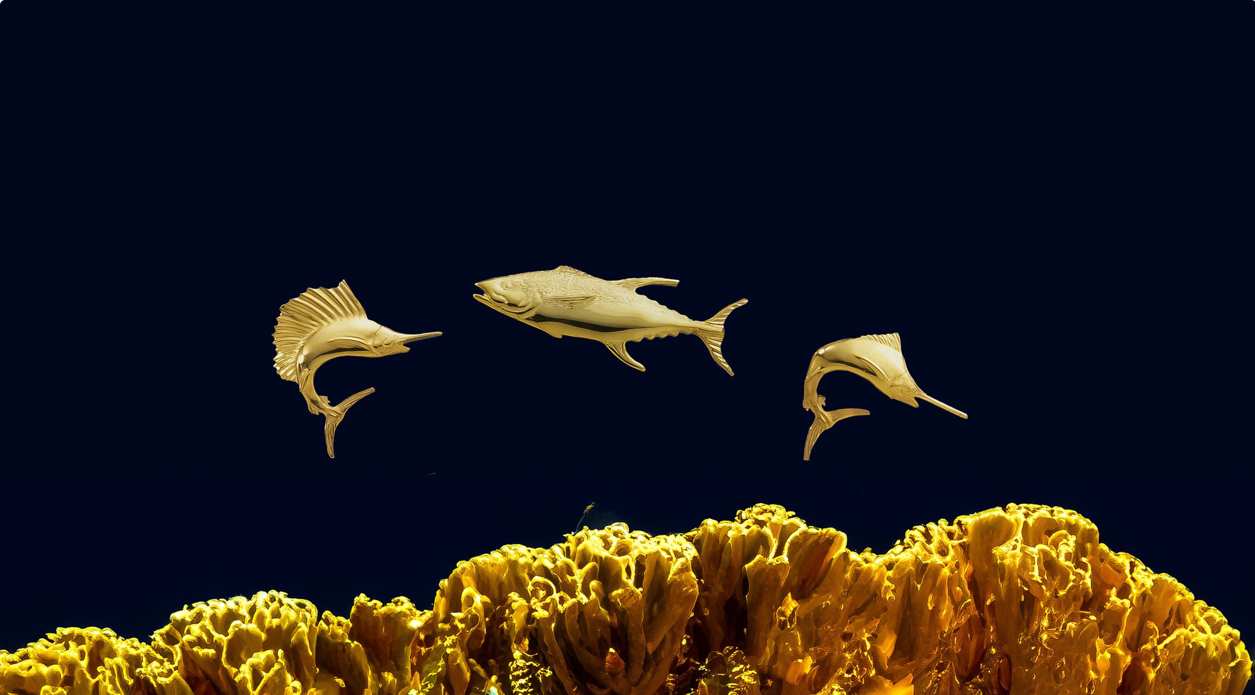 Golden sculptures of fishes with coral background.