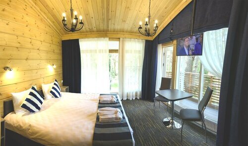 НОМЕР DELUXE PANORAMIK Проживание на 2 персоны > Кровать kingsize или 2 односпальные кровати - на ваш выбор > Угловые панорамные окна > Собственная терраса с мебелью > Минихолодильник, чайник, посуда для сервировки > Кофемаши