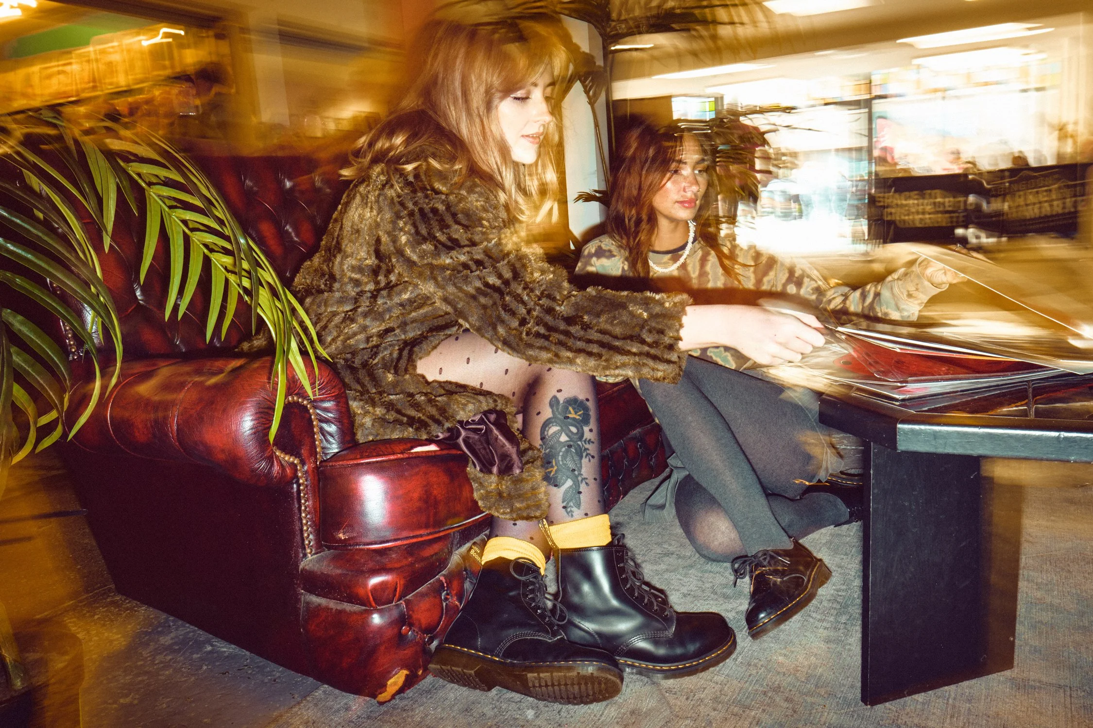 Dr. Martens lifestyle campaign portrait featuring black boots and youth culture styling inside a record shop.