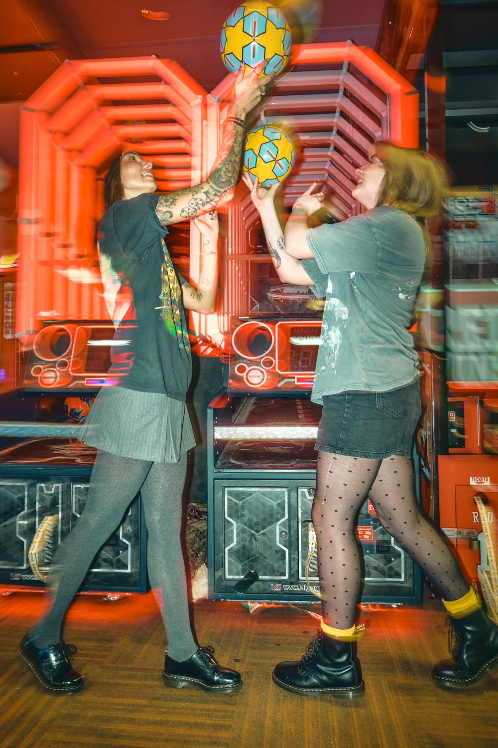 Creative Dr. Martens campaign photography inside a neon-lit arcade, combining movement, front flash and authentic youth culture storytelling for a commercial fashion campaign.