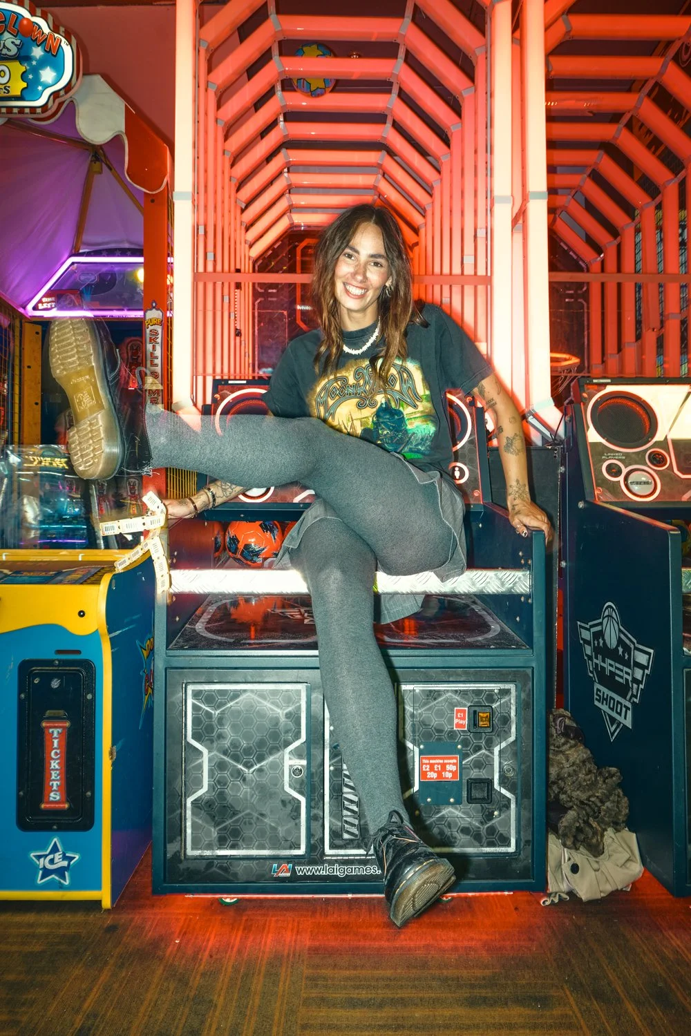 Creative Dr. Martens campaign photography inside a neon-lit arcade, combining movement, front flash and authentic youth culture storytelling for a commercial fashion campaign.