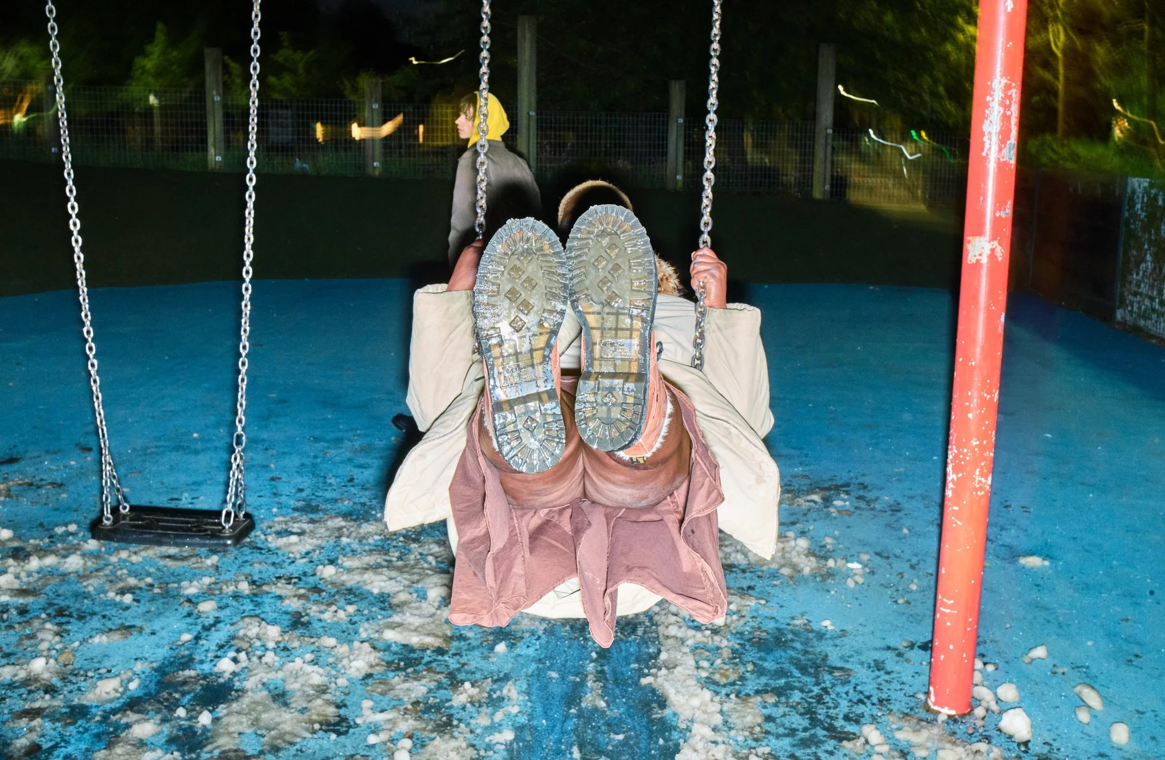 Lifestyle fashion photograph of Dr. Martens boots on a swing during the Reclaim Winter campaign.