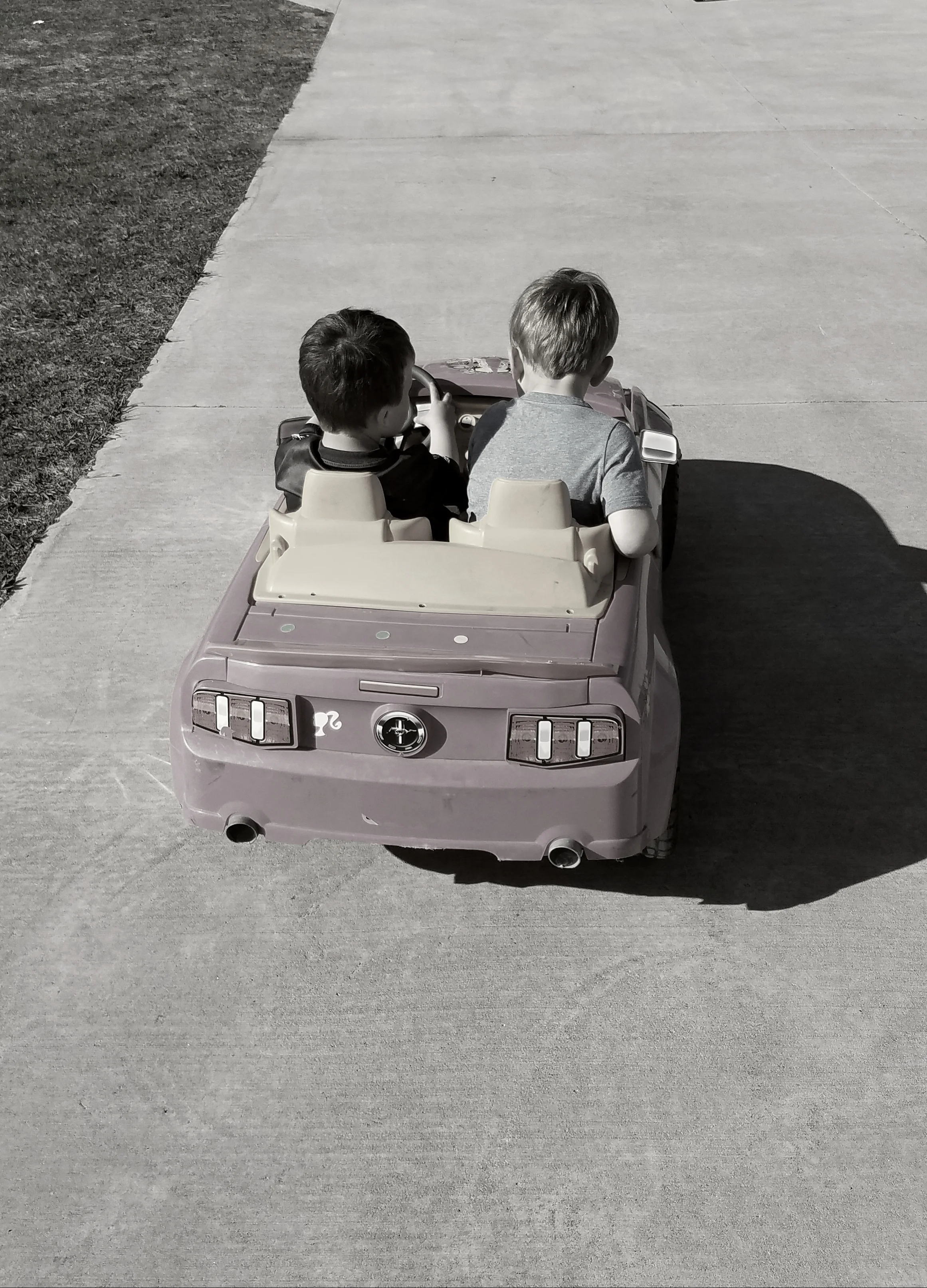 My son, the backseat driver, with his cousin behind the wheel.