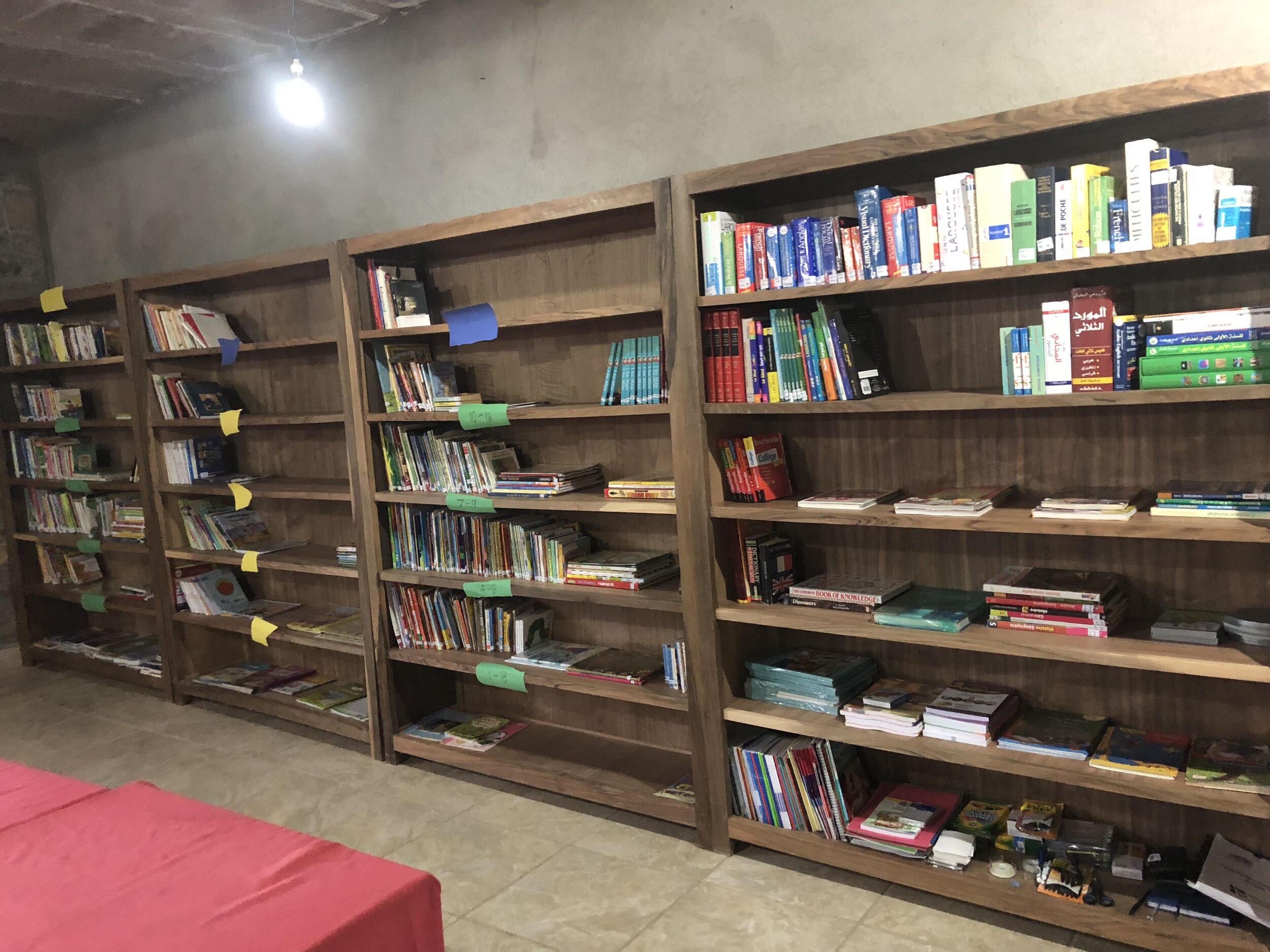  The library in Morocco being organized by language (French, Arabic, and English), reading level, and genre. 