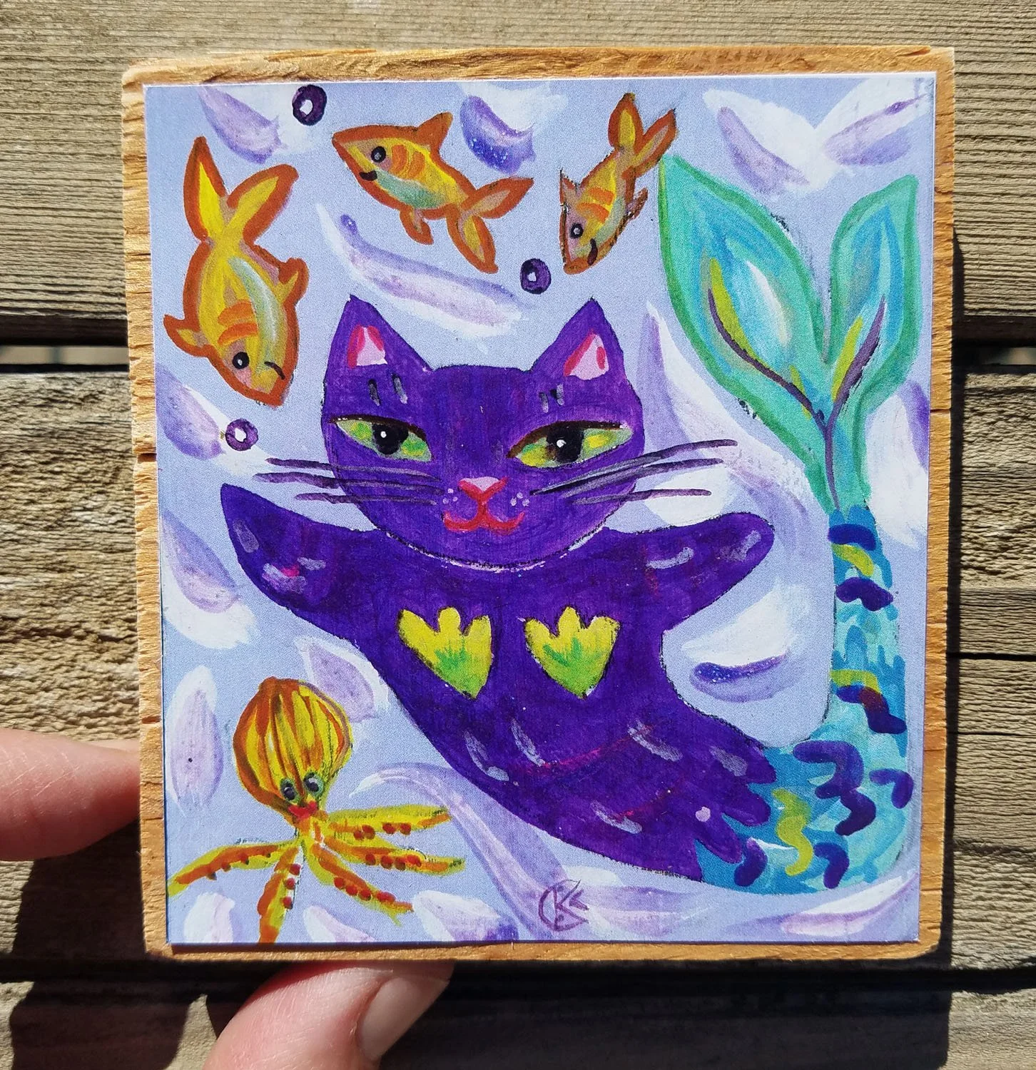 Mer Magician print on wood in hand 3.75 x 3.25.jpg
