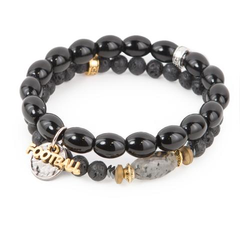 Game Day (Set of Two) Black lava rock and glass bracelet set of two with mixed metal detail and football charms. Measures approximately 7.5" in length. With the purchase of this bracelet set, 25% of gross profit goes to Gift for Life. All bracelet sets come with a pouch and a hang-tag detailing the mission of each charity. 