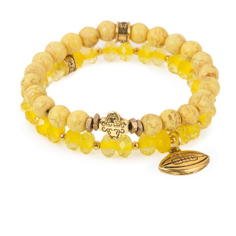 First and Goal (Set of Two) Yellow magnesite and crystal glass bracelet set of two with gold ornate accent and football charm. Measures approximately 7.5" in length. With the purchase of this bracelet set, 25% of gross profit goes to Alex's Lemonade Stand Foundation. All bracelet sets come with a pouch and a hang-tag detailing the mission of each charity. 