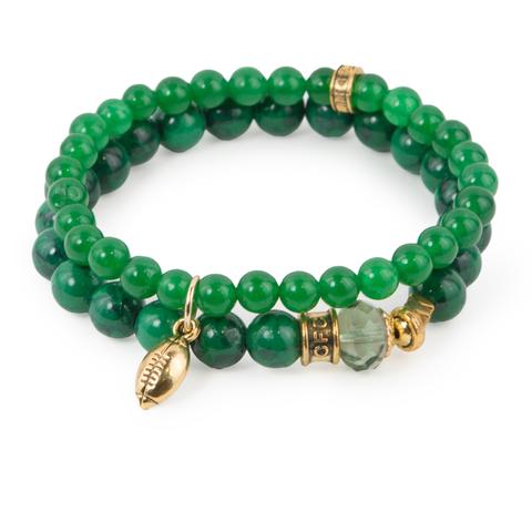 Go, Fight, Win (Set of Two) Green-dyed jade and synthetic turquoise bracelet set of two with Czech glass accent and gold mini football charm. Measures approximately 7.5" in length. With the purchase of this bracelet set, 25% of gross profit goes to the Whole Planet Foundation. All bracelet sets come with a pouch and a hang-tag detailing the mission of each charity. 