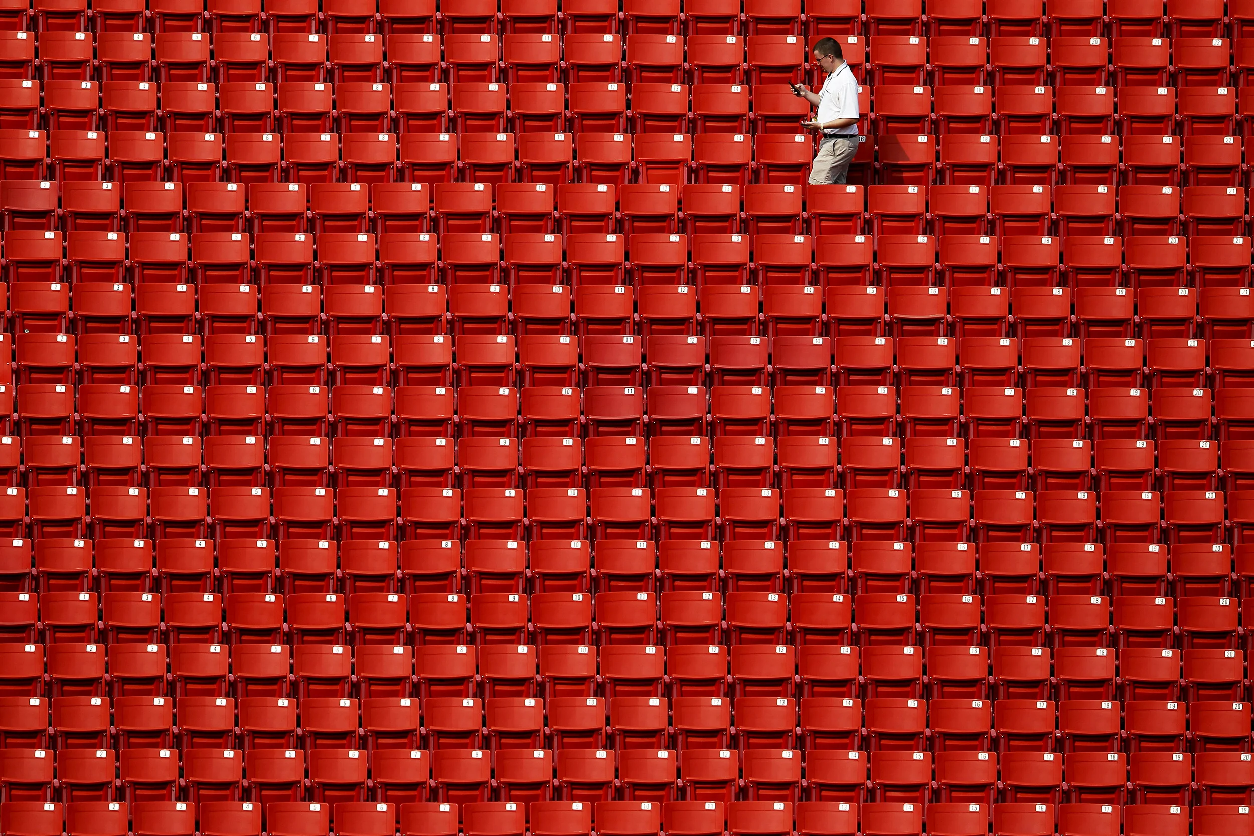A Washington Redskins employee walks through the stands before a preseason game against the New England Patriots at FedExField on Thursday, Aug. 7, 2014.