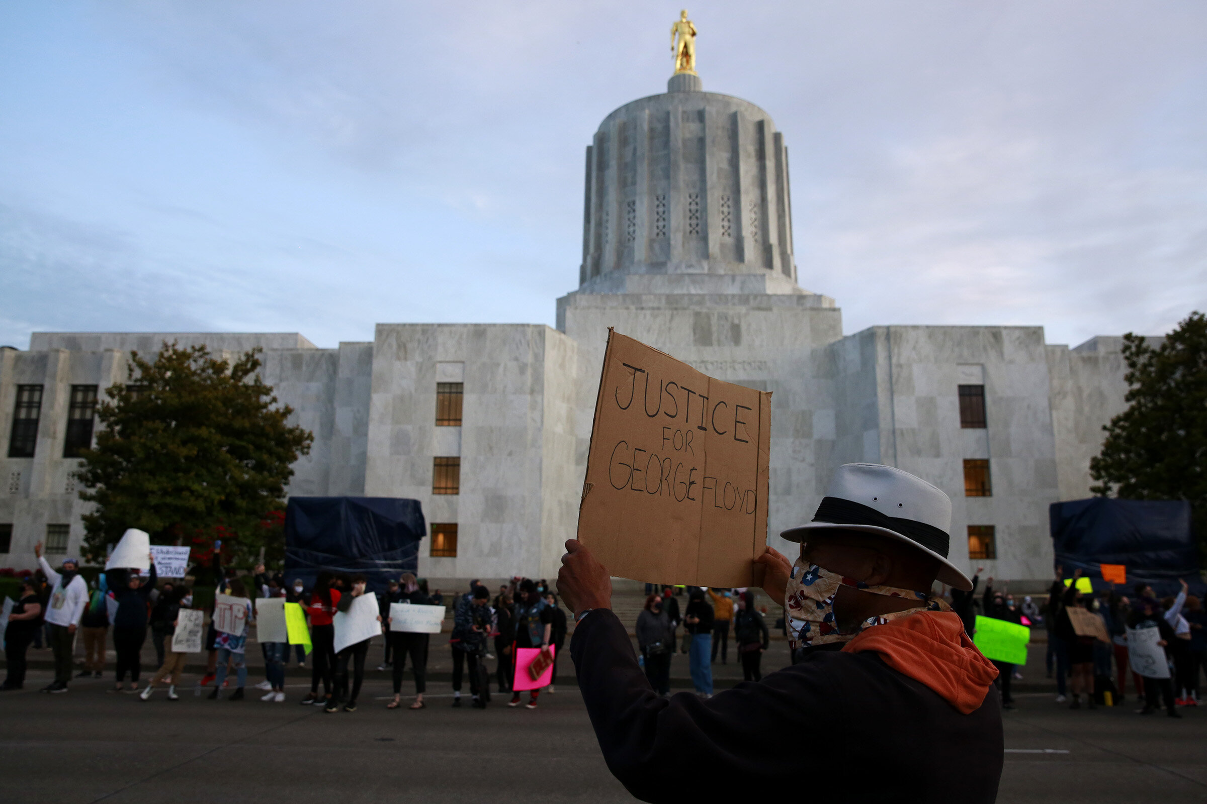  Donga de Abeokuta of Salem holds a sign reading “Justice for George Floyd” while participating in a protest of Floyd’d death outside the Oregon State Capitol Building in Salem, Oregon, on Sunday, May 31, 2020. 