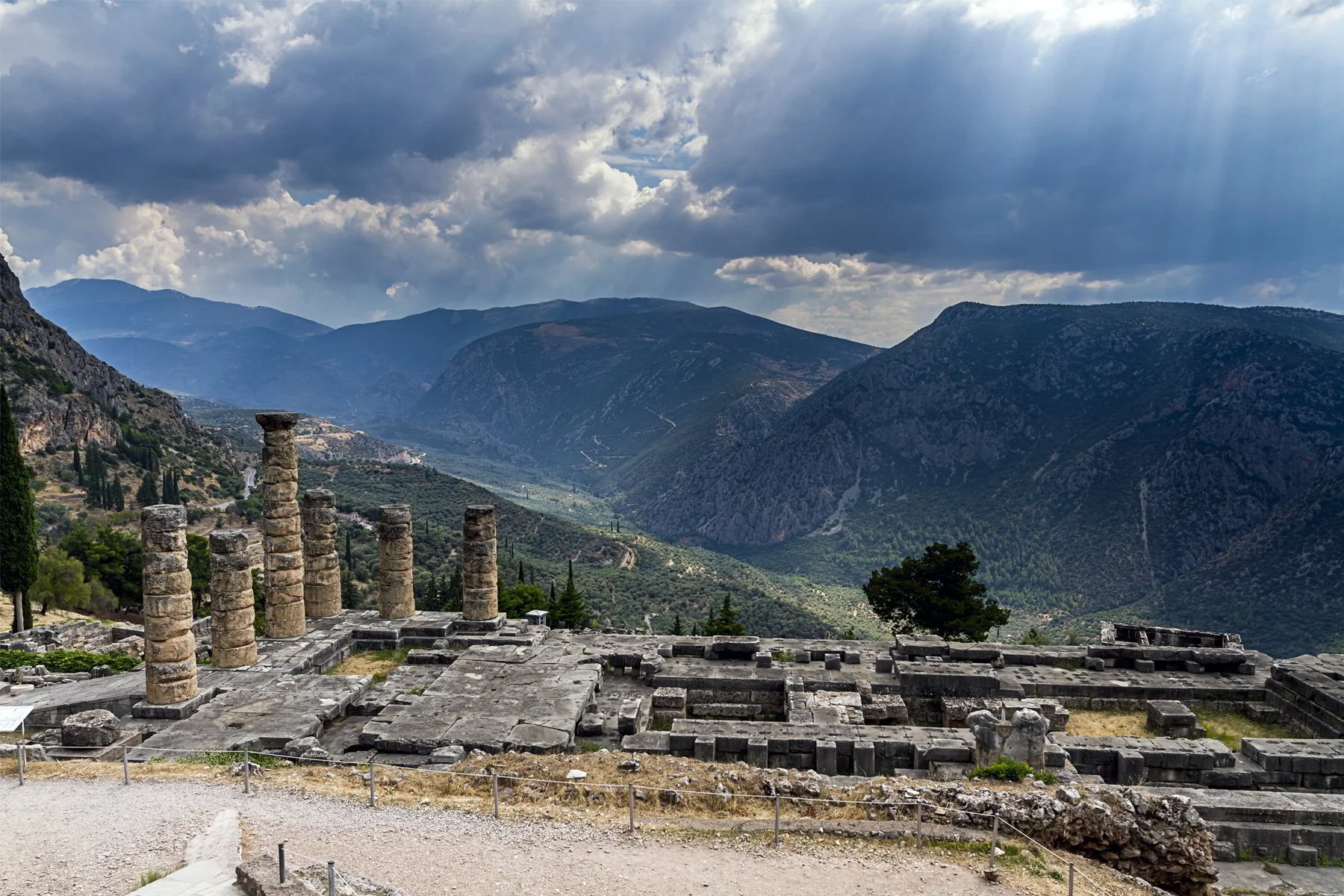 ancient-ruins-of-delphi-and-the-sun-peaking-through-the-clouds.jpg