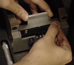 Figure 4 - This shows the Charpy Specimen Centering Gage. Notice how the silver notch of the tool enters the notch cutout in the black plastic specimen.