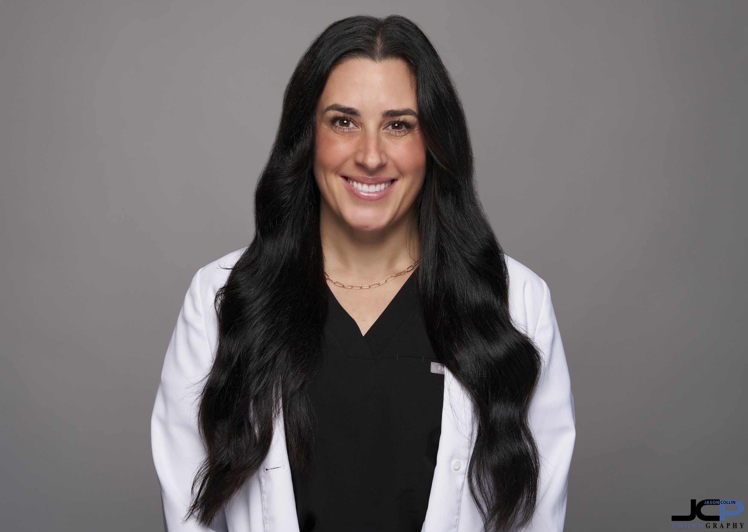 Professional studio headshot of Dr. Jamie Klinefelter, dentist in Pacific Grove, photographed on a modern gray background for her dental practice website.