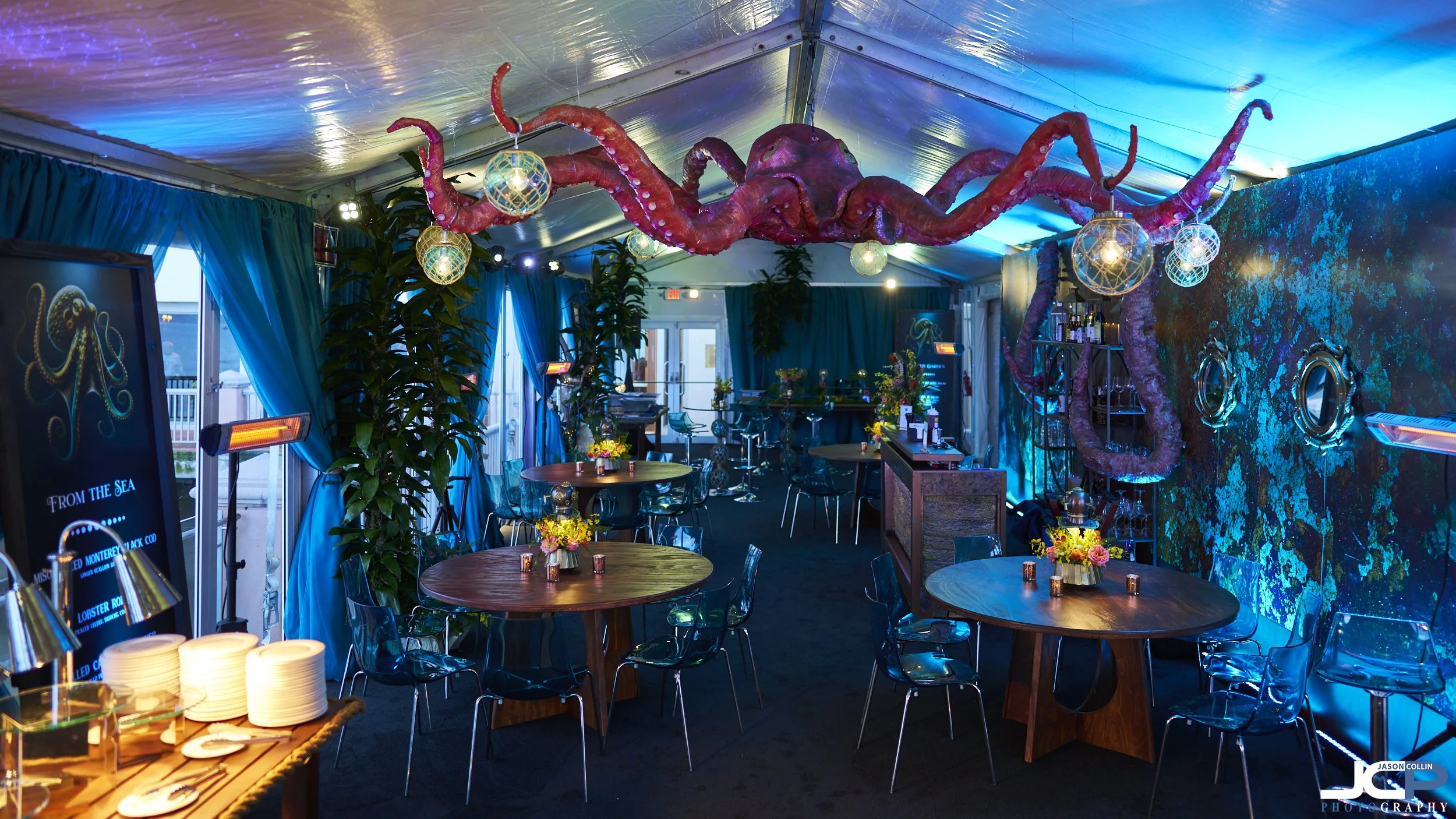 Underwater-themed event setup at Monterey Plaza Hotel featuring large red octopus ceiling installation, custom tables, and sea-inspired décor for AT&T Pro-Am event.