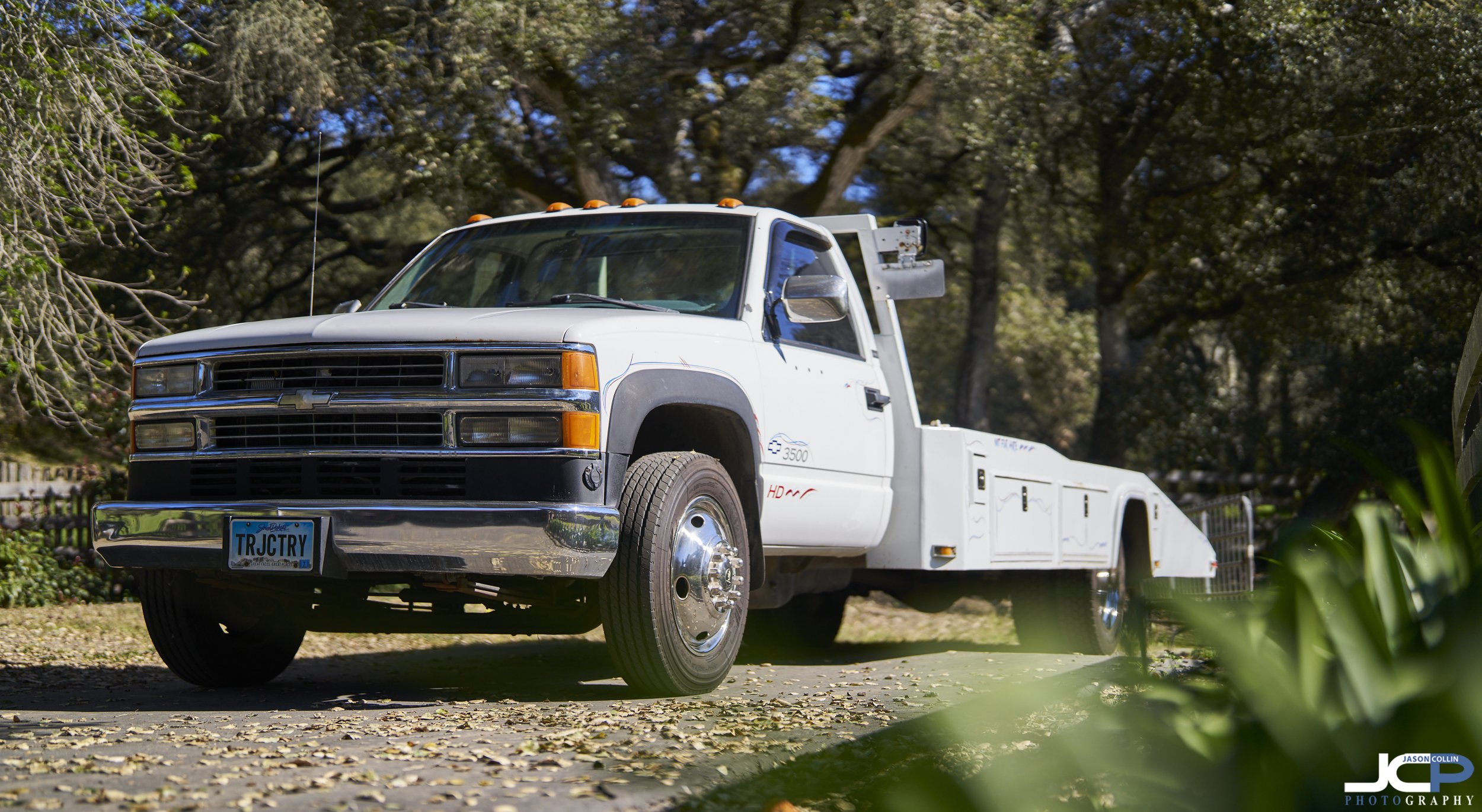 996 Chevrolet C3500HD ramp truck photographed for Cars & Bids auction, side profile view of custom trailer-style pickup conversion