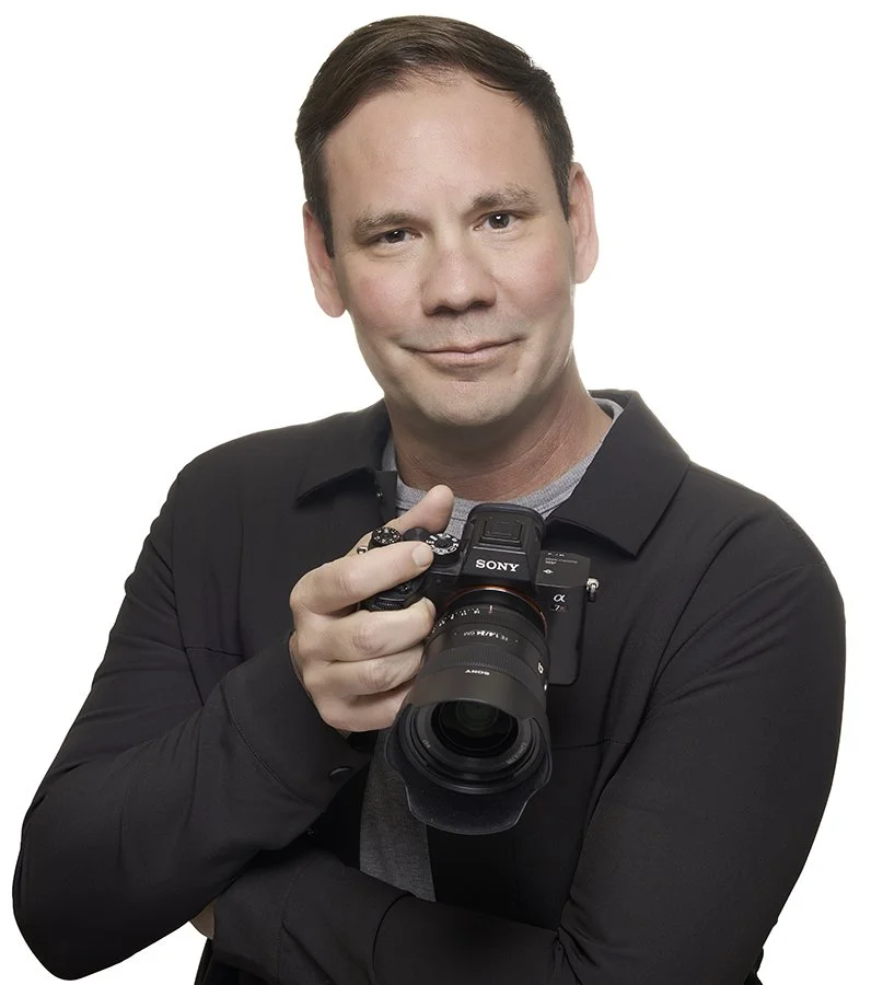 Jason Collin Professional Photography holding his Sony mirrorless camera in studio in Pacific Grove California