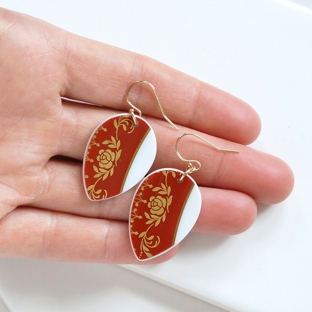 Vintage China made into drop shaped dangle earrings that are red and gold. With gold fill ear wires.