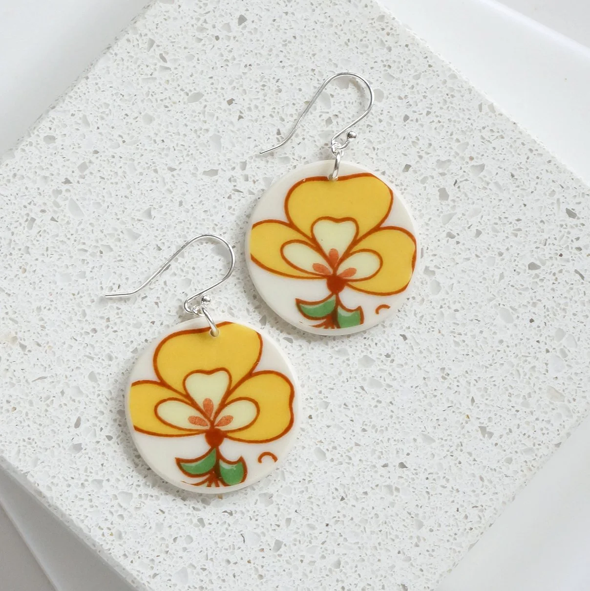 Round orb shaped Earrings made from vintage china with bright yellow retro flowers, and sterling silver ear wires by material and movement