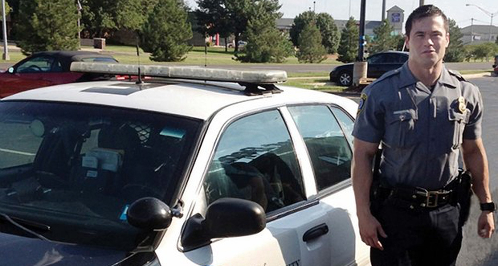 Daniel Holtzclaw standing next to an Oklahoma City Police patrol vehicle.