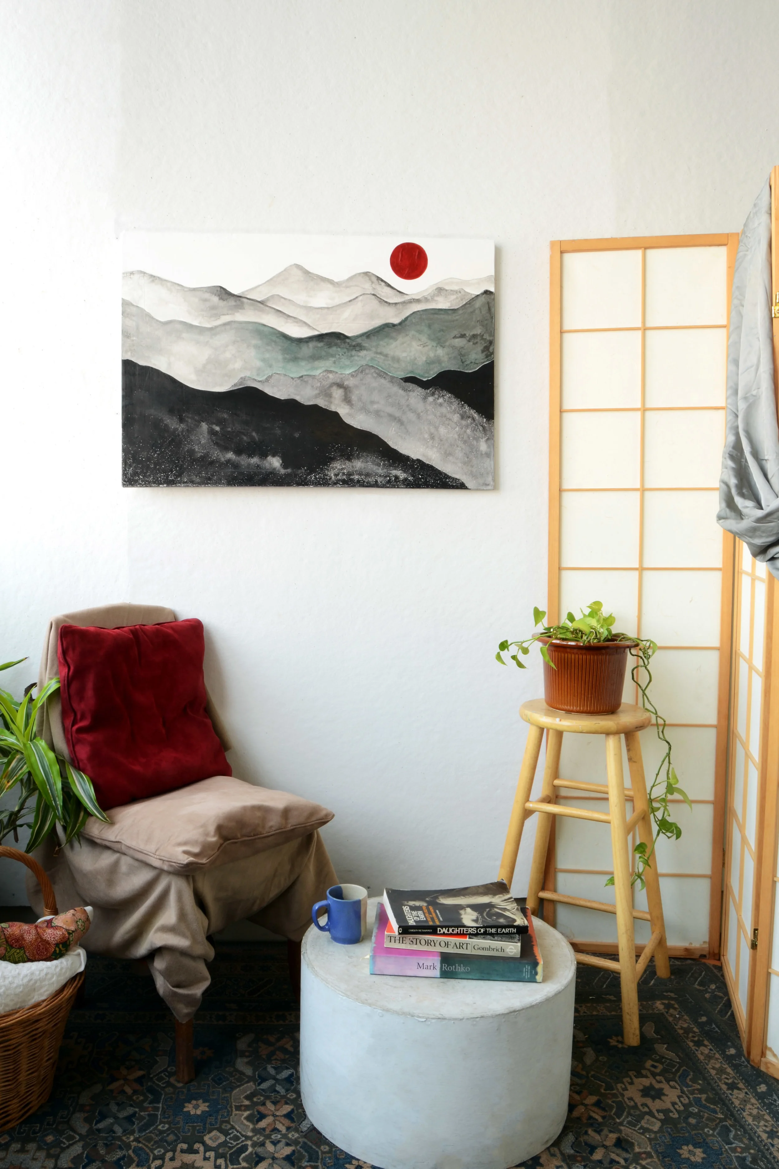 Red moon rise over gray mountain range painting on wall